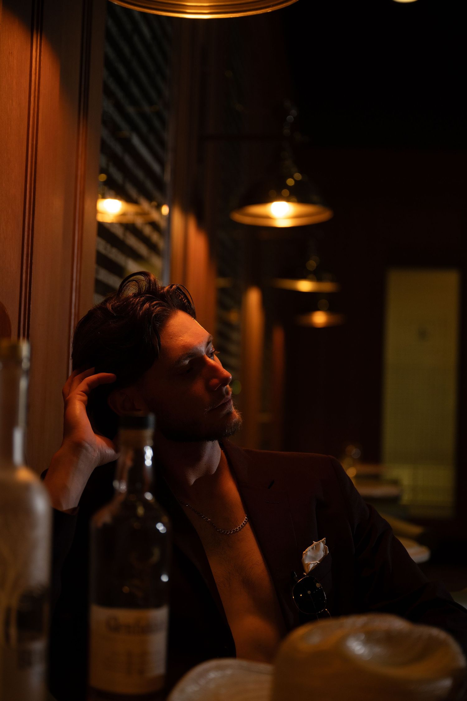 Dimly lit bar scene with glasses and bottles in warm ambient lighting.