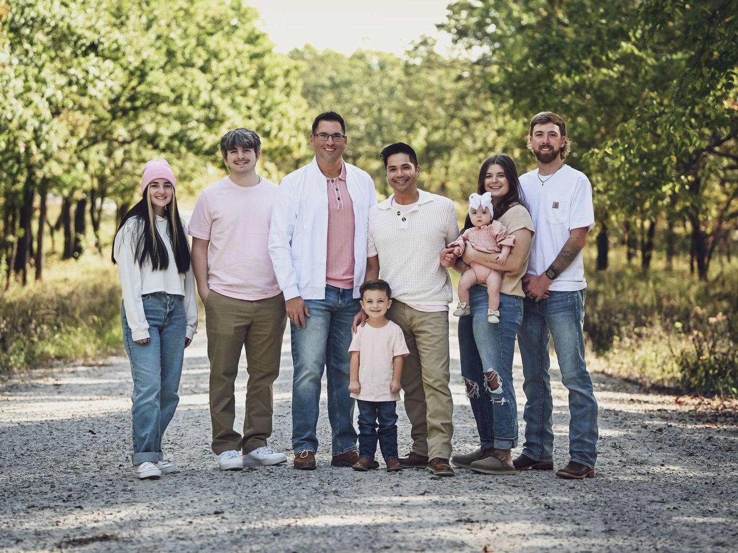 Family members walking together on gravel path through natural setting.