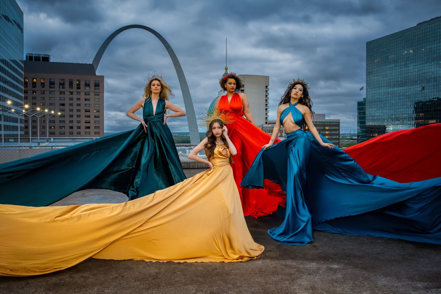 Dramatic fashion shoot with flowing fabric in blue, red and yellow against St. Louis cityscape and stormy sky.