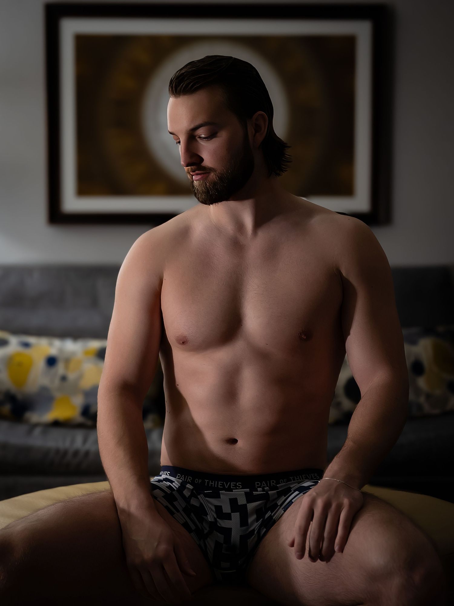 Intimate indoor portrait series with natural window lighting and dark shadows.