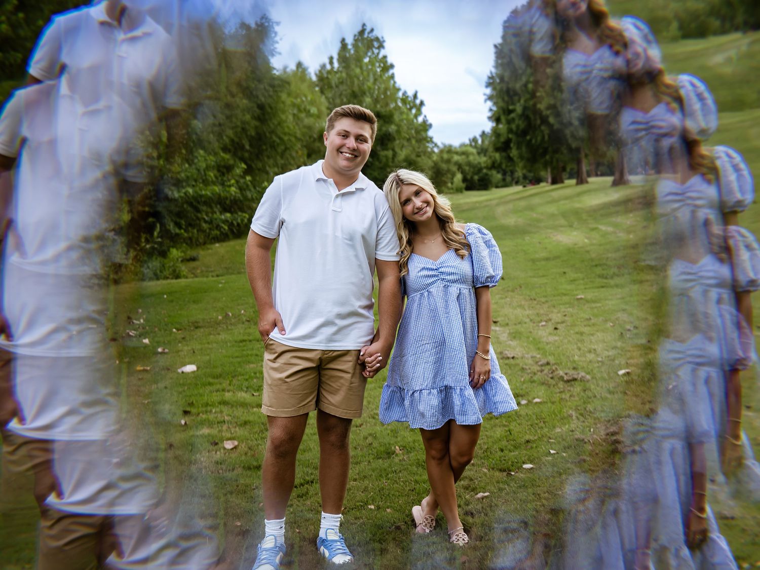 Romantic outdoor photo session with couple in blue dress and white shirt in grassy field.