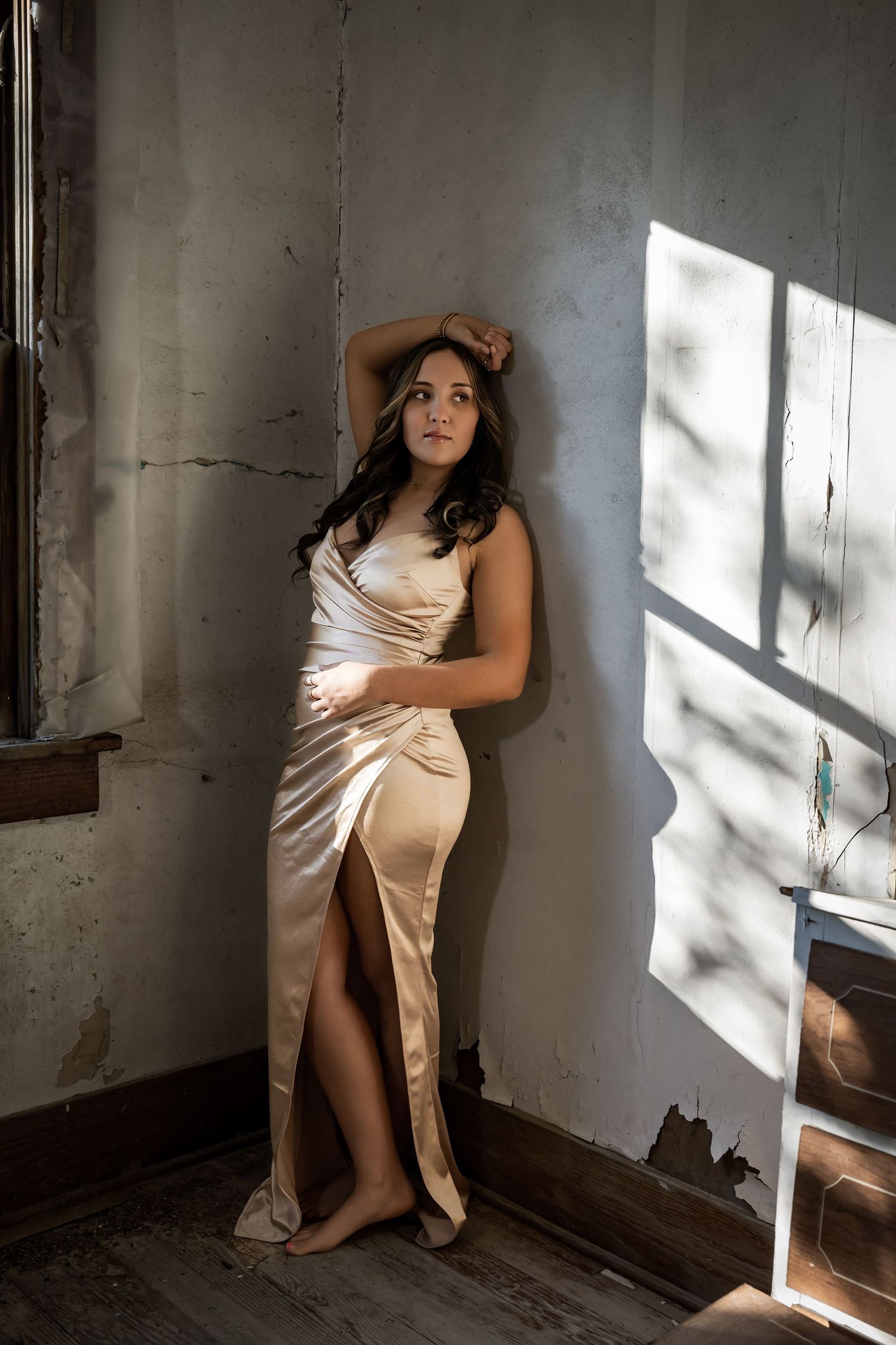 Artistic portrait series showing dramatic lighting and shadows on figure in silk dress.