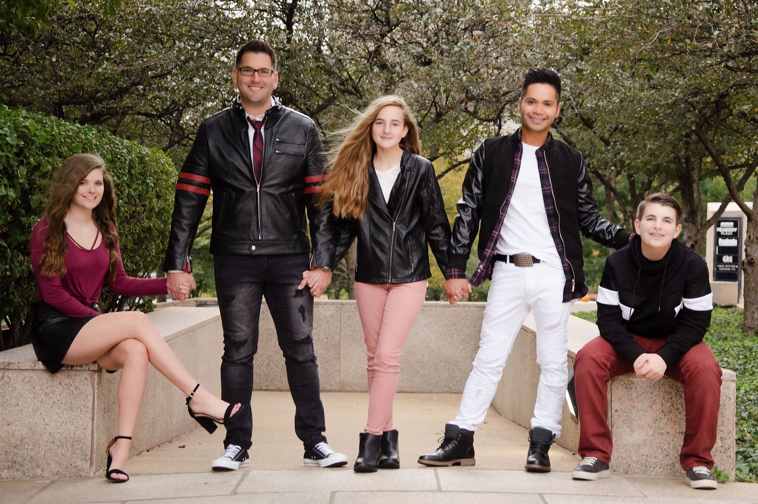 People's feet and legs lined up in casual poses against outdoor backdrop.