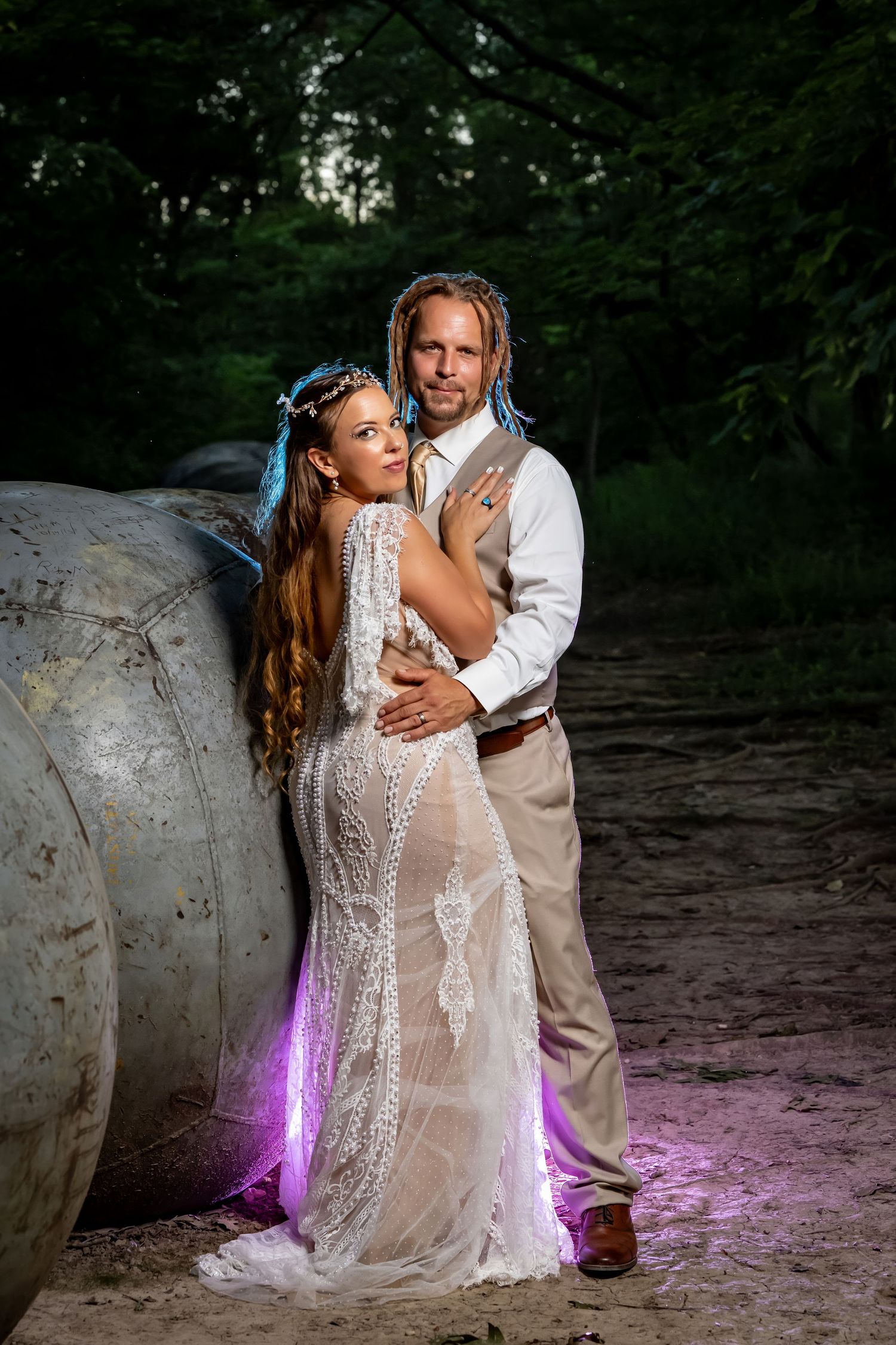 Dramatic wedding photos with purple lighting effects against natural rock formations.