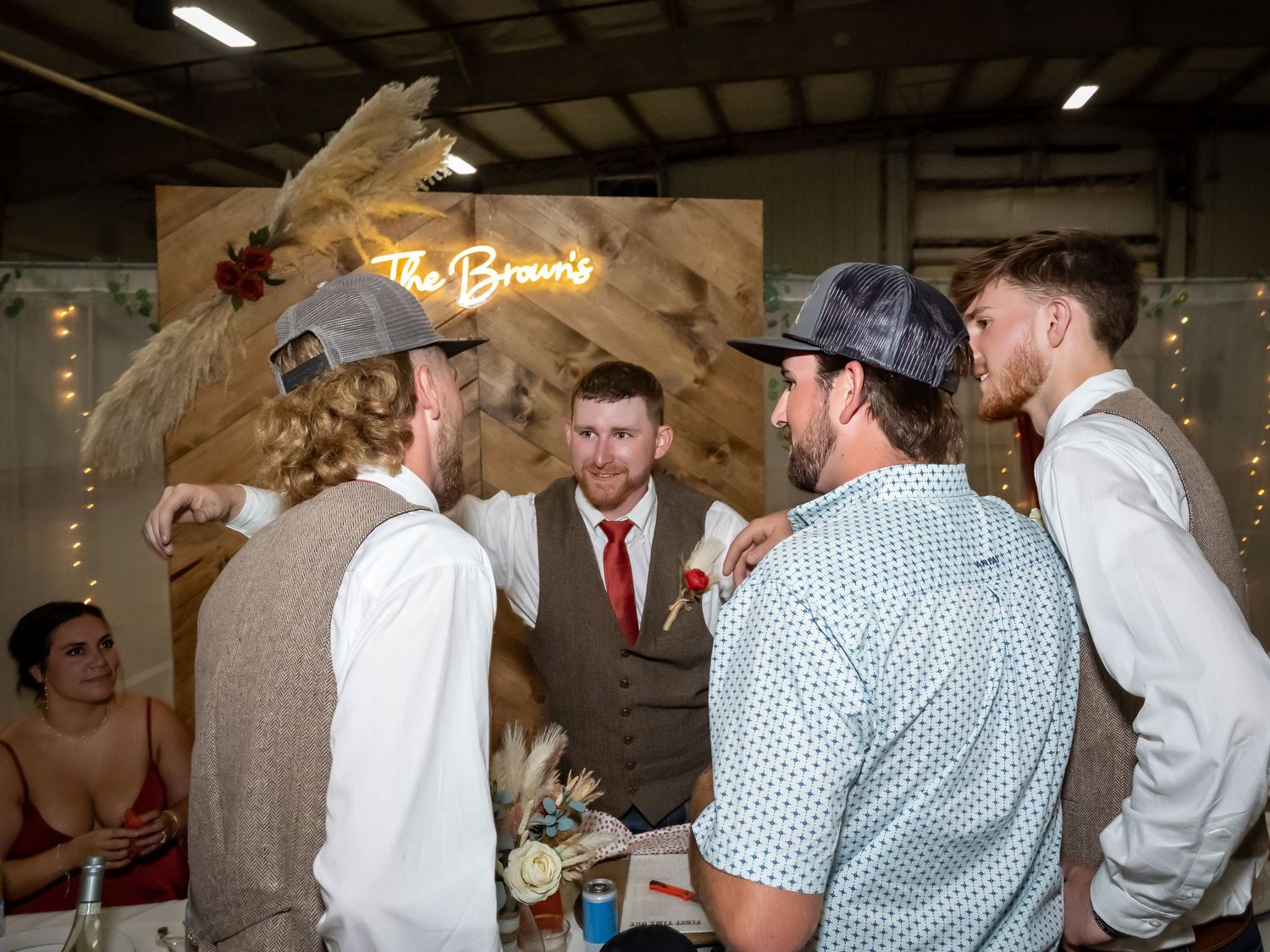 Wedding reception dance party in rustic barn venue with string lights.