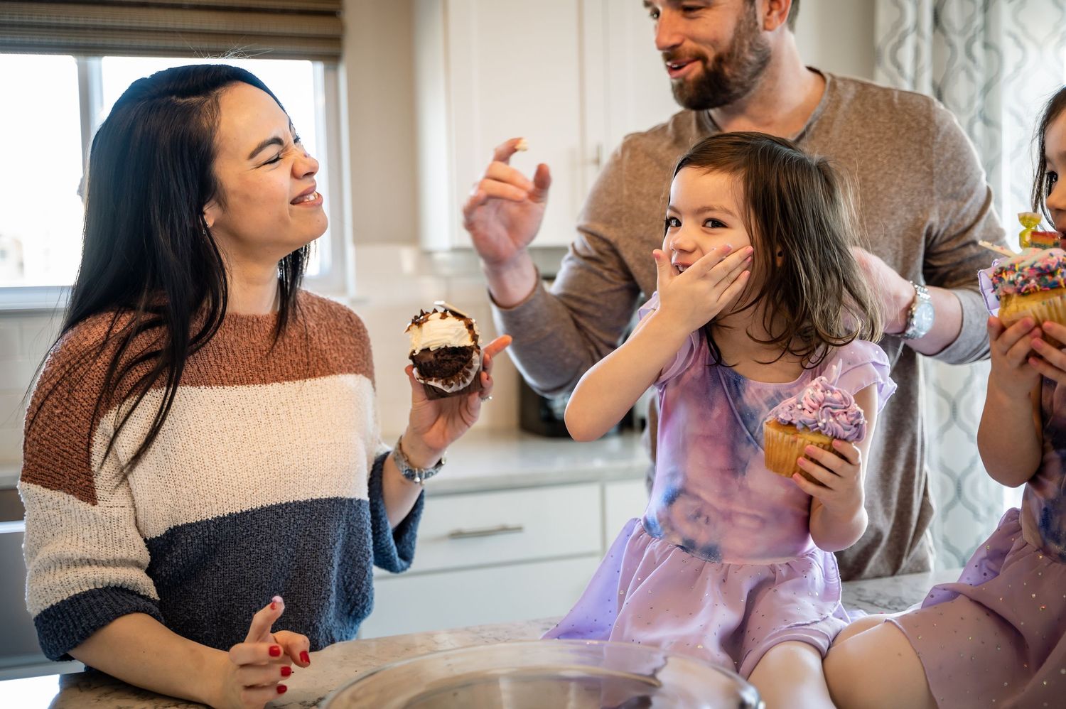 Family sharing sweet treats and laughter together in a bright indoor setting.