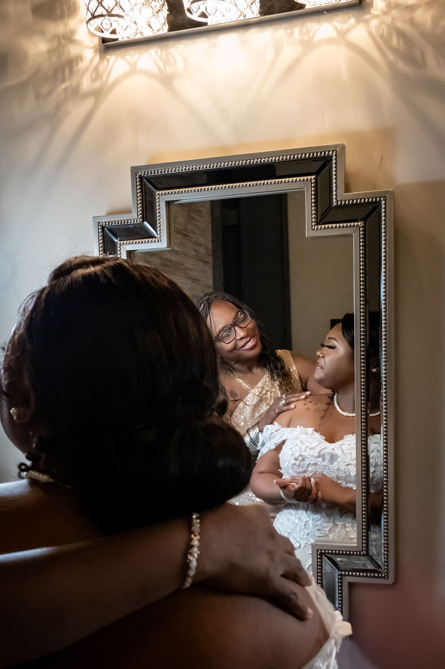 Elegant bridal preparation scene reflected in framed mirrors.