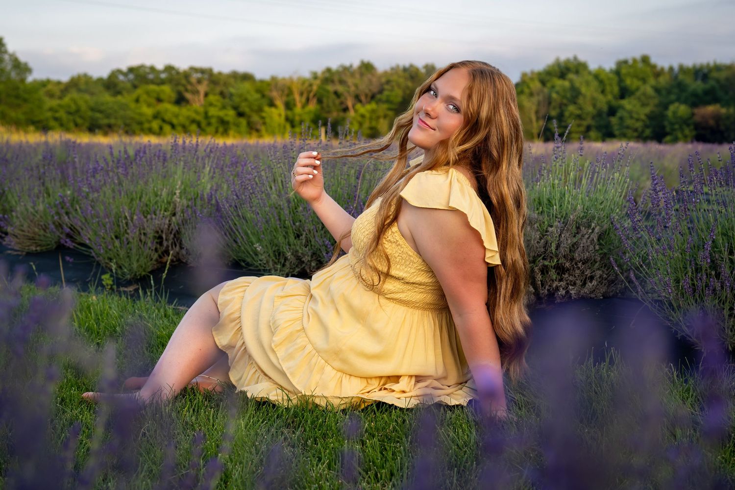A yellow sundress flows in a lavender field during golden hour sunset.