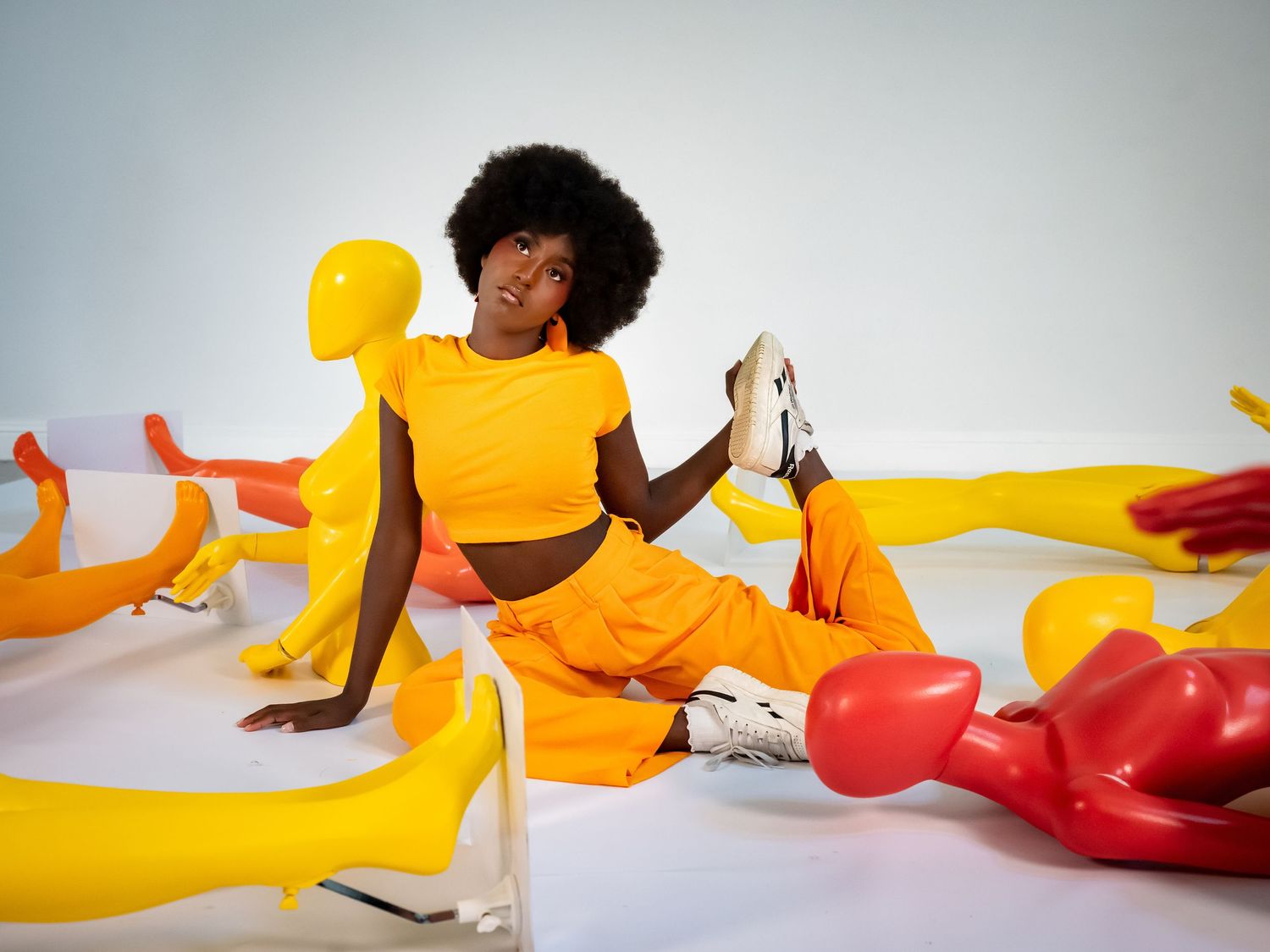 Dynamic poses of figures in vibrant yellow and red bodysuits against white backdrop.