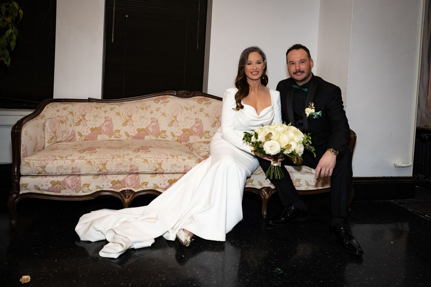 Elegant wedding ceremony setup with white chairs and warm lighting in a modern venue.