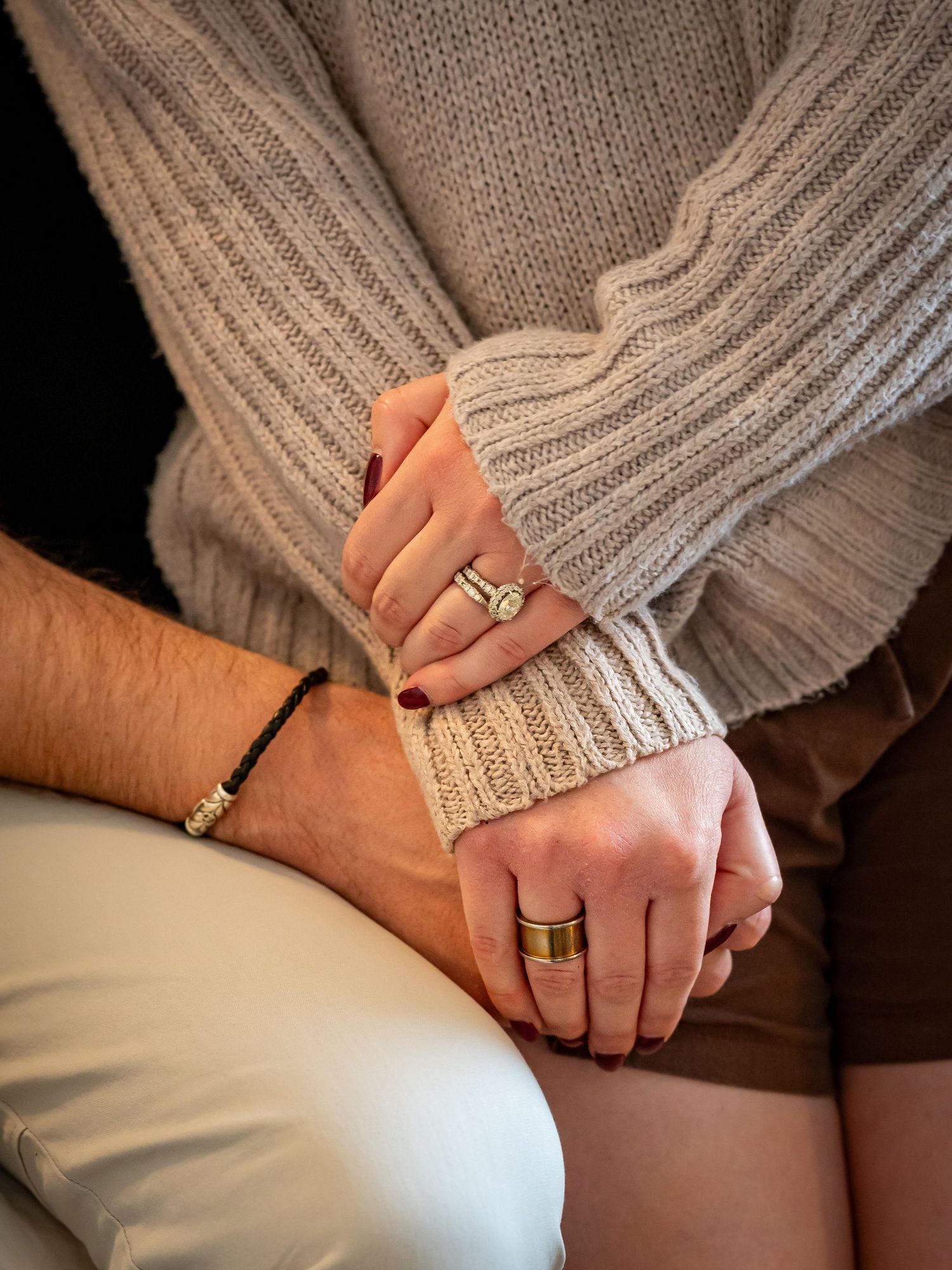 Close-up of hands with wedding rings showing intimate connection.
