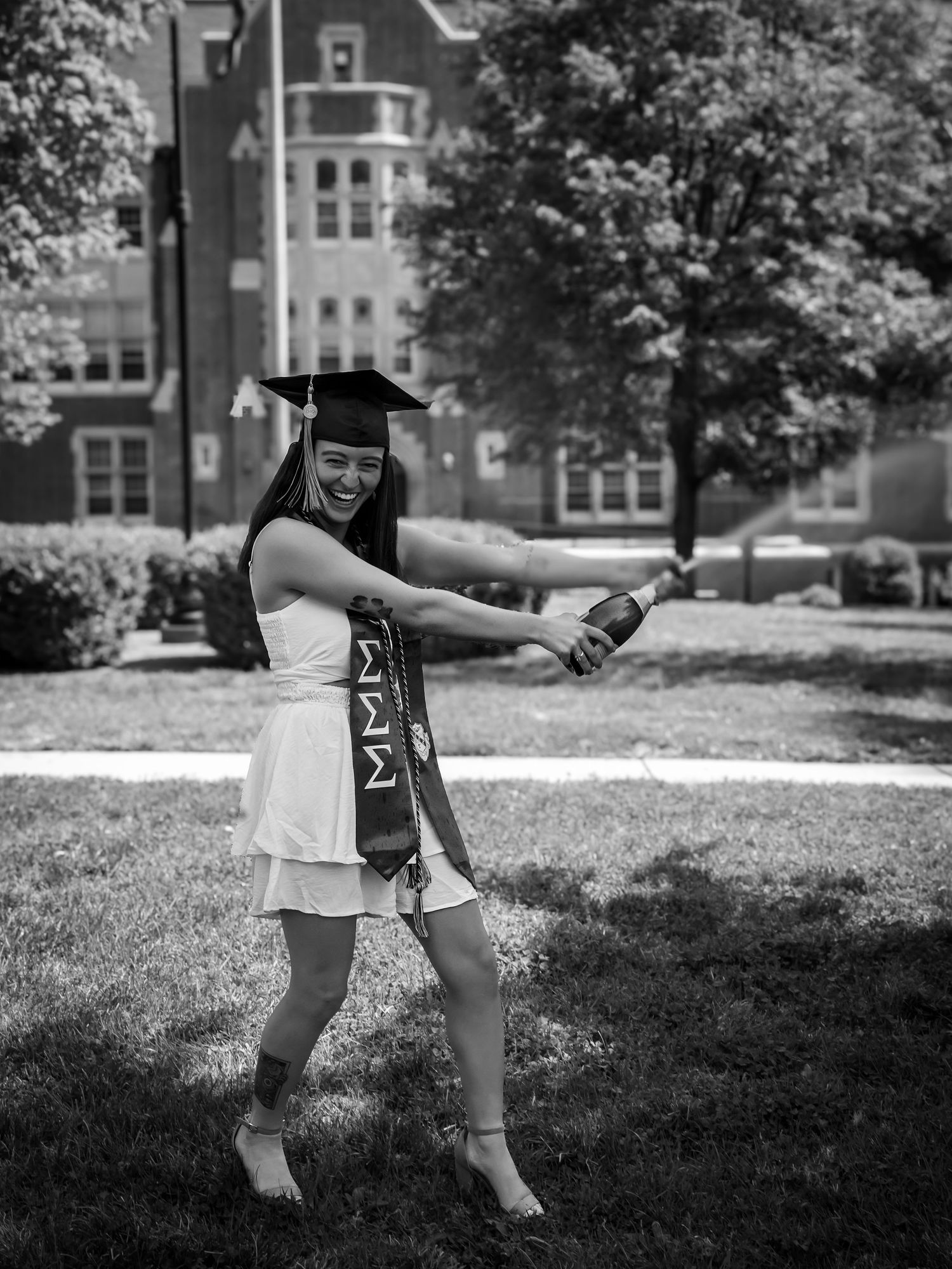 Black and white graduation photos on a college campus lawn.