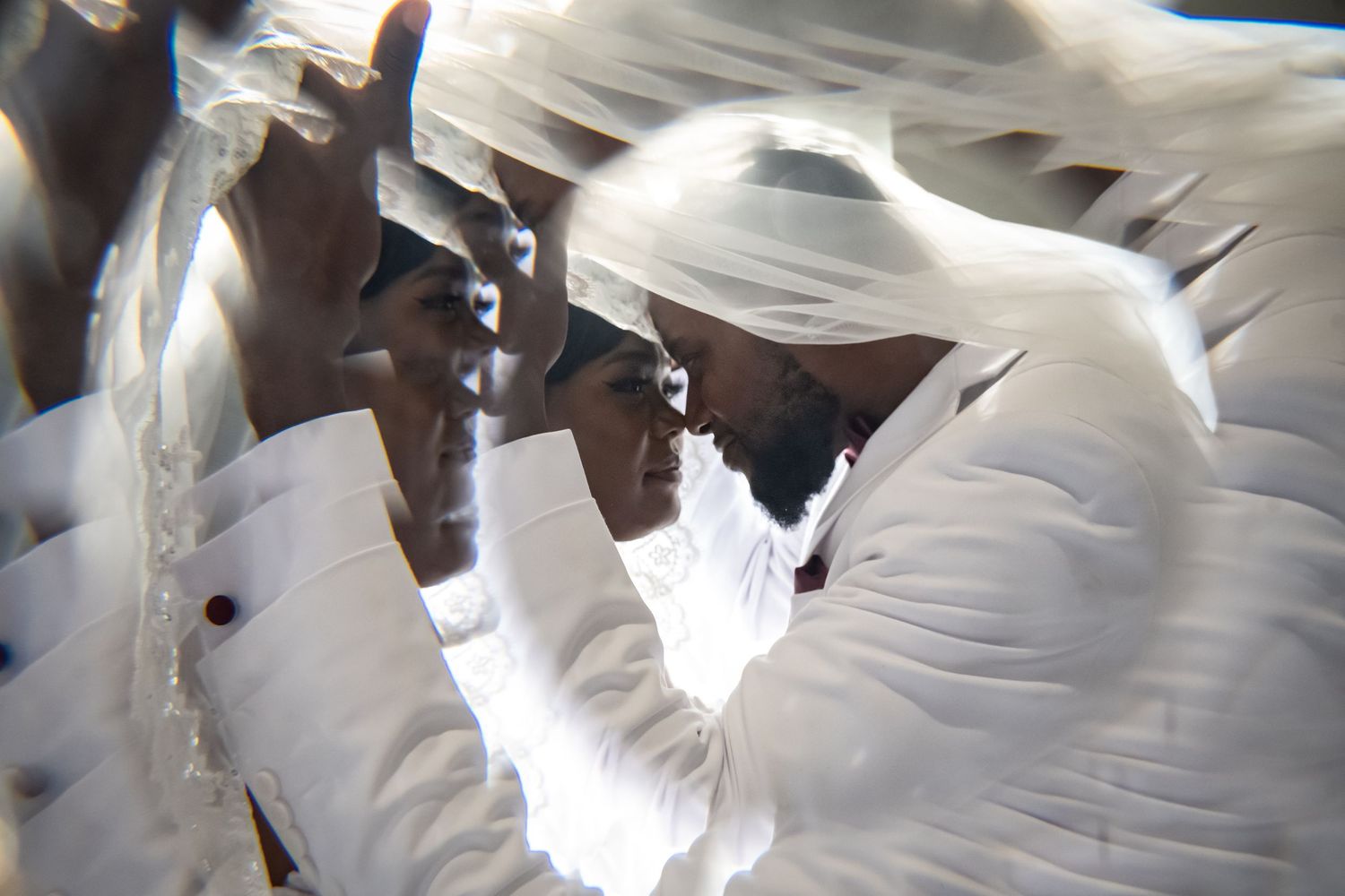Abstract close-up of flowing white fabric in motion against bright lighting.