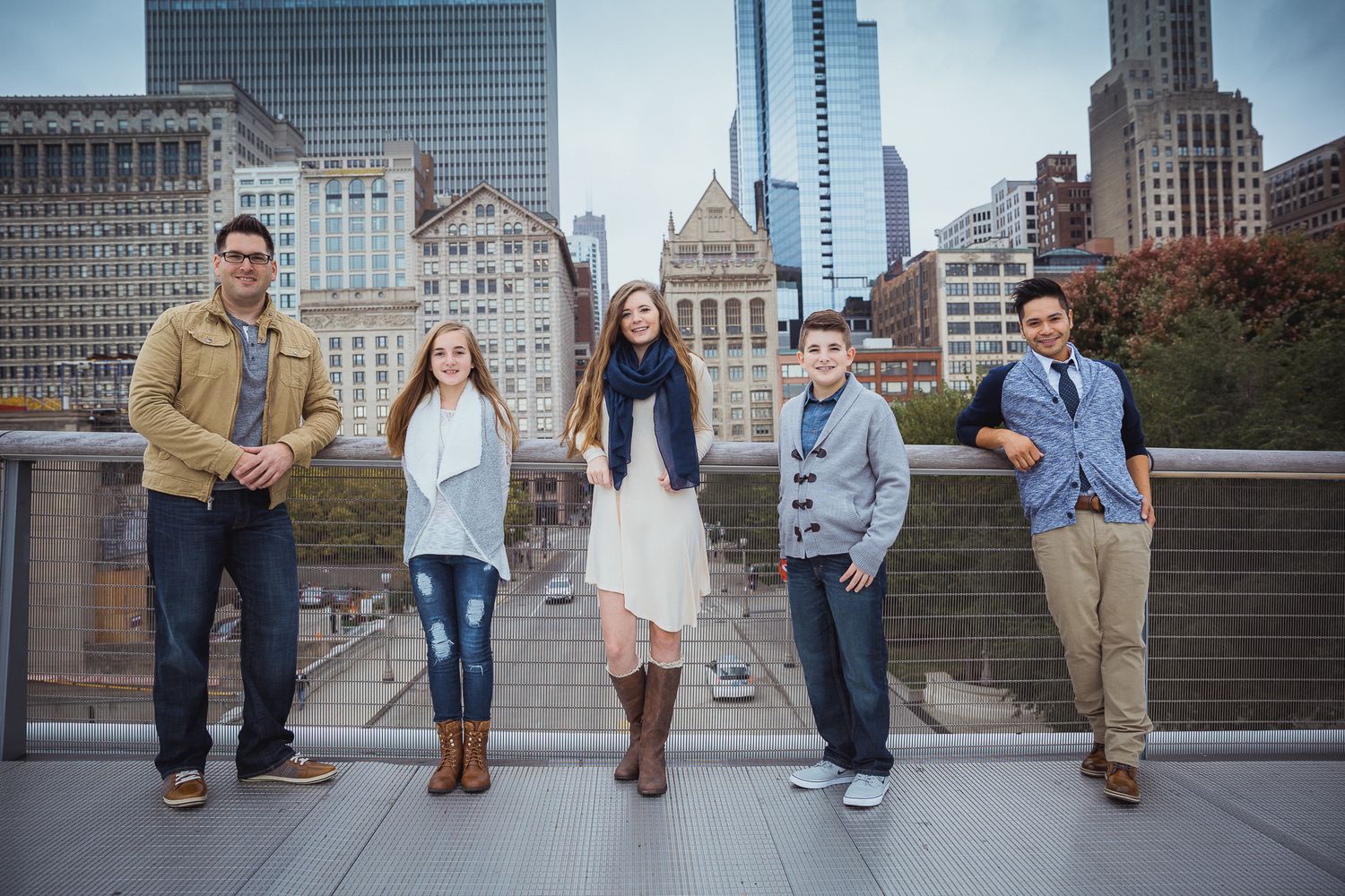 Urban family photo shoot with city skyline and architecture in background.
