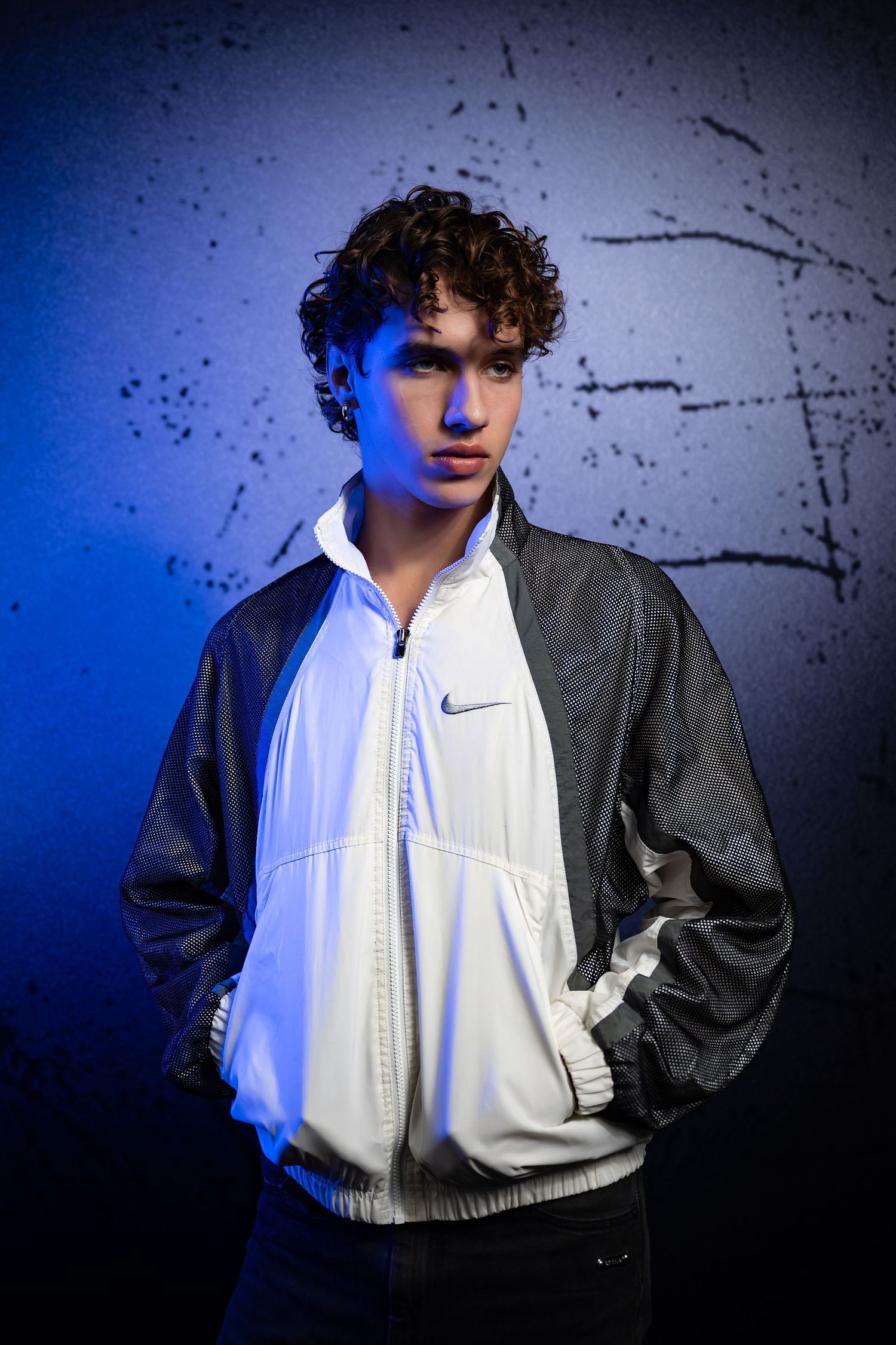 Sporty fashion photo featuring a black and white Nike jacket against a blue background.