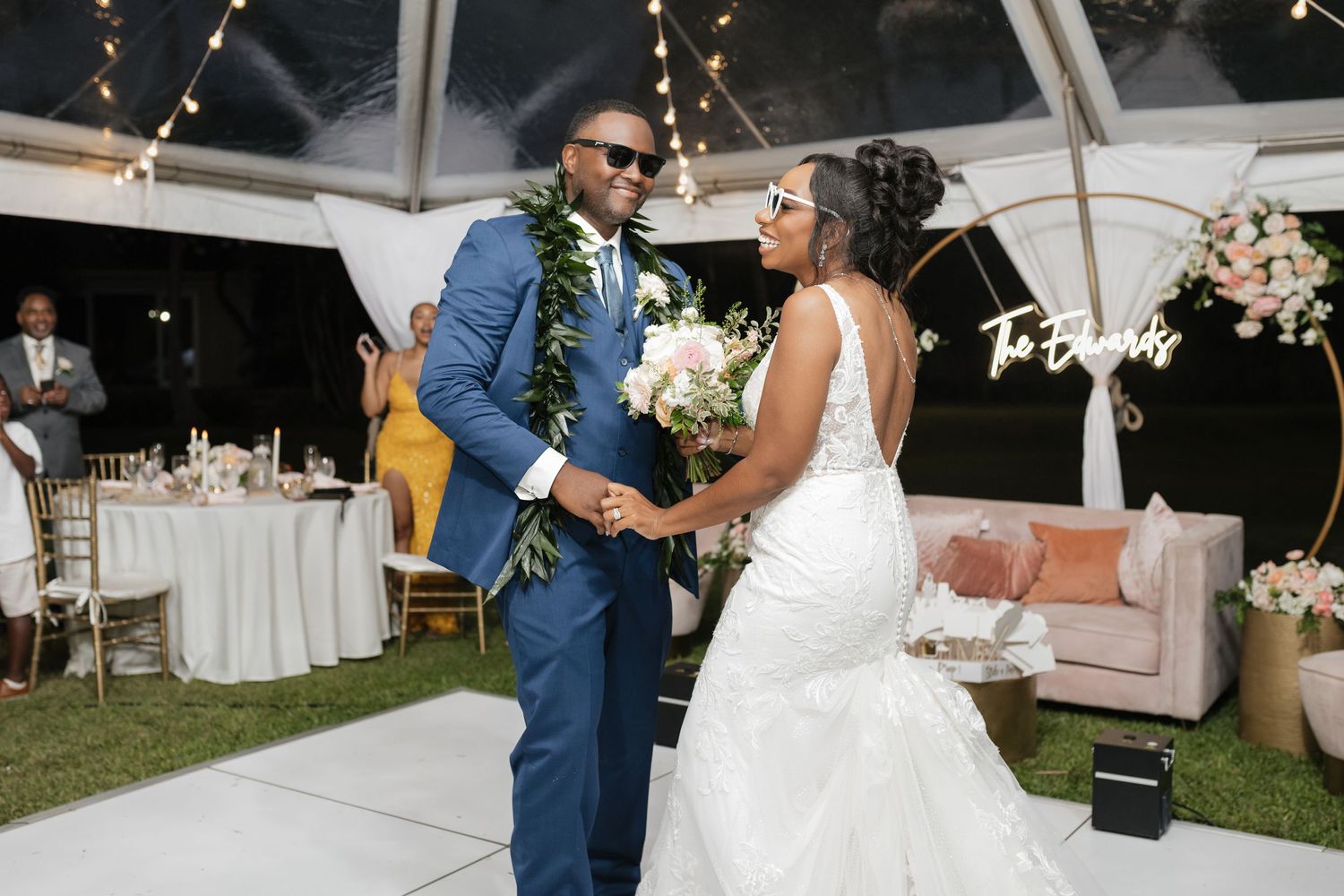 Wedding celebration at an outdoor venue with romantic lighting and palm trees.