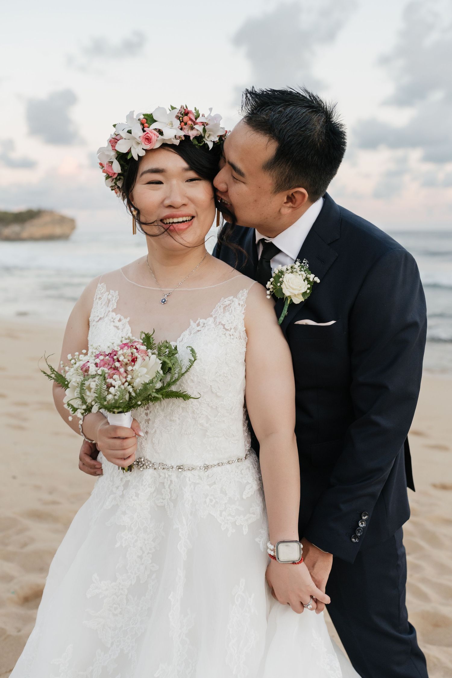 Tender wedding moments captured on a tropical beach with flower crown details.