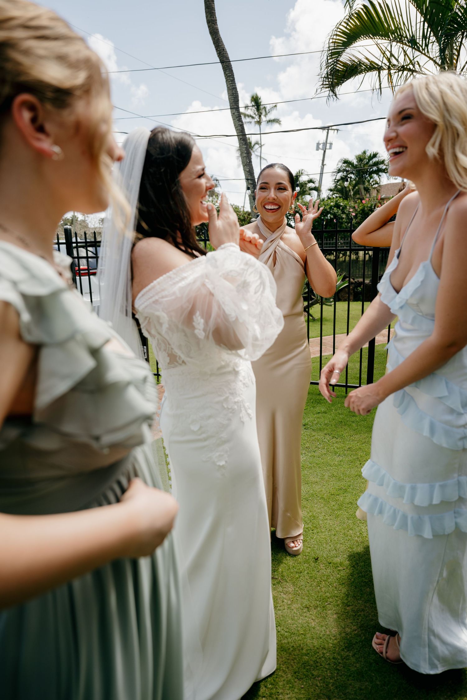 Wedding party shares laughter and embraces during an outdoor celebration.