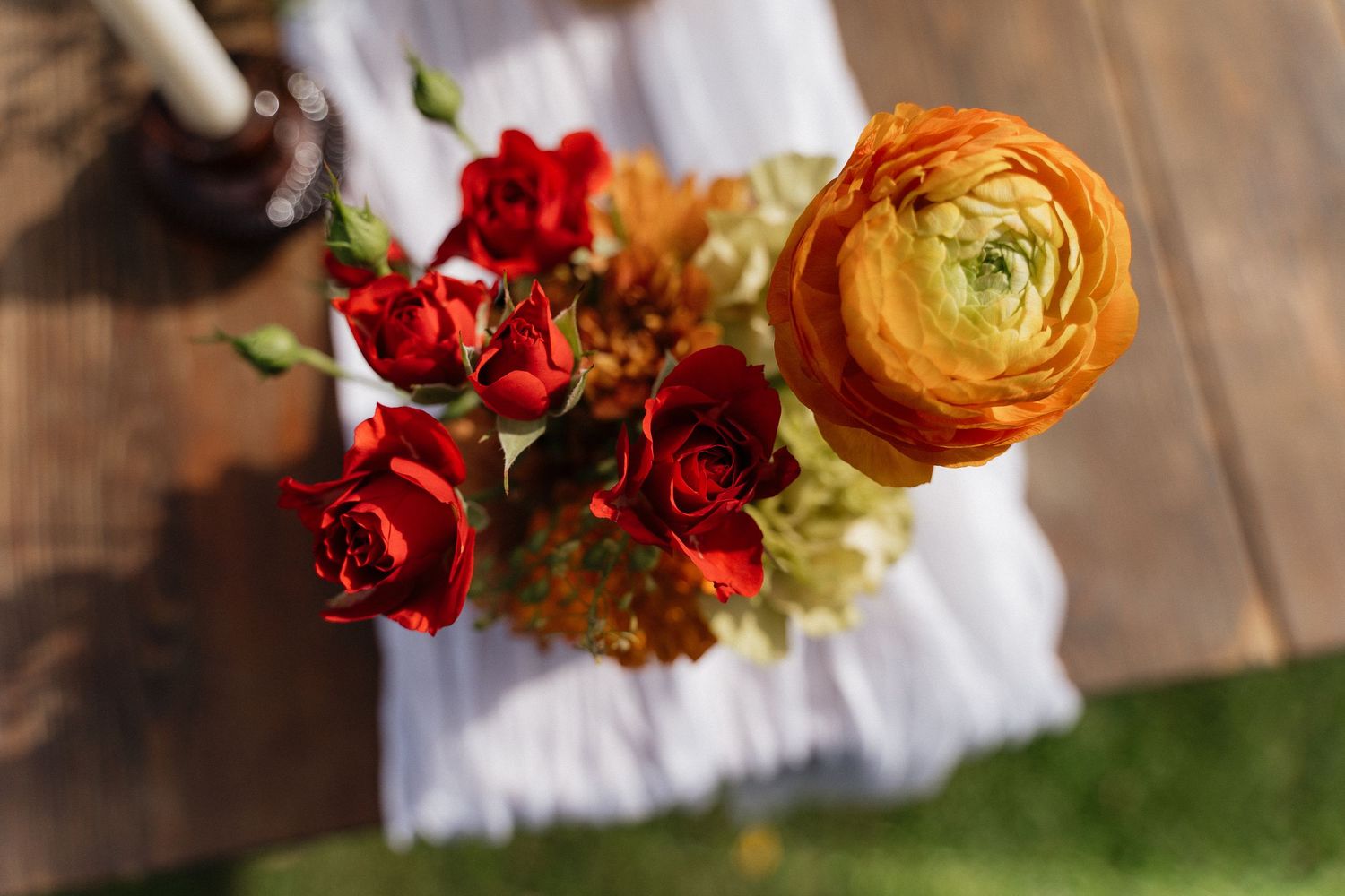 Close-up of vibrant red and orange ranunculus flowers in wedding decor.