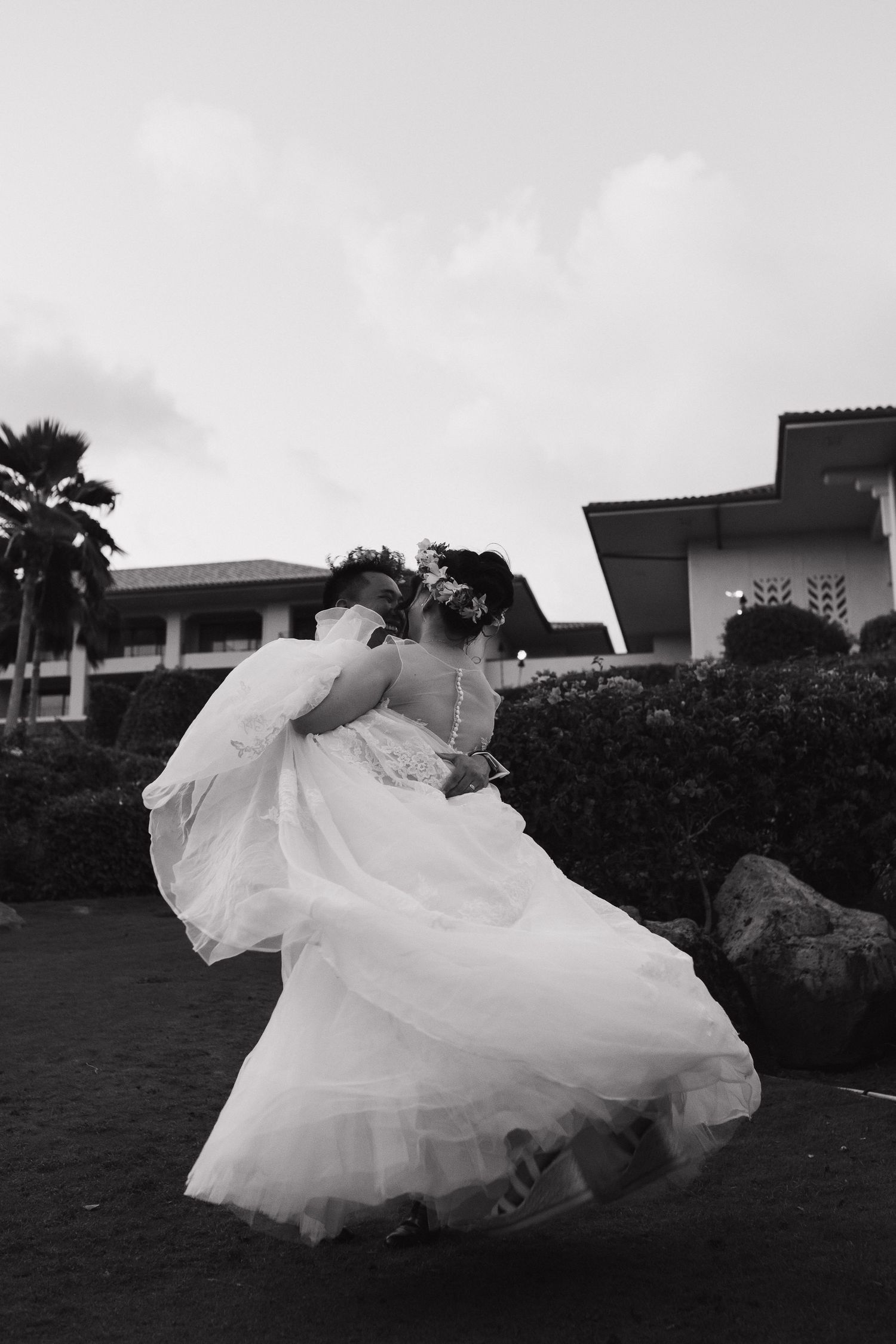 A flowing white wedding dress billows dramatically against a dark background creating an artistic silhouette effect.