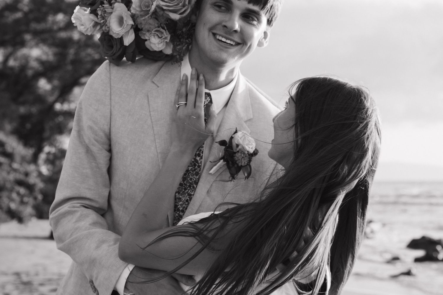 A happy couple shares a joyful moment on their wedding day in this vintage black and white photograph.