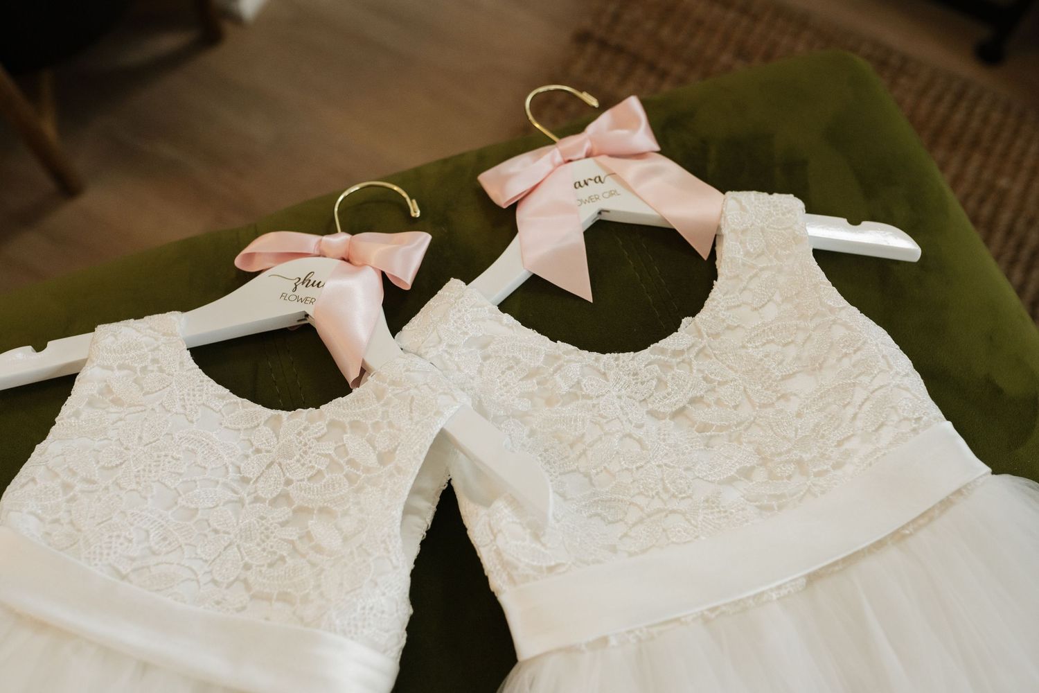 White wedding dresses hanging on delicate hangers against a natural background.