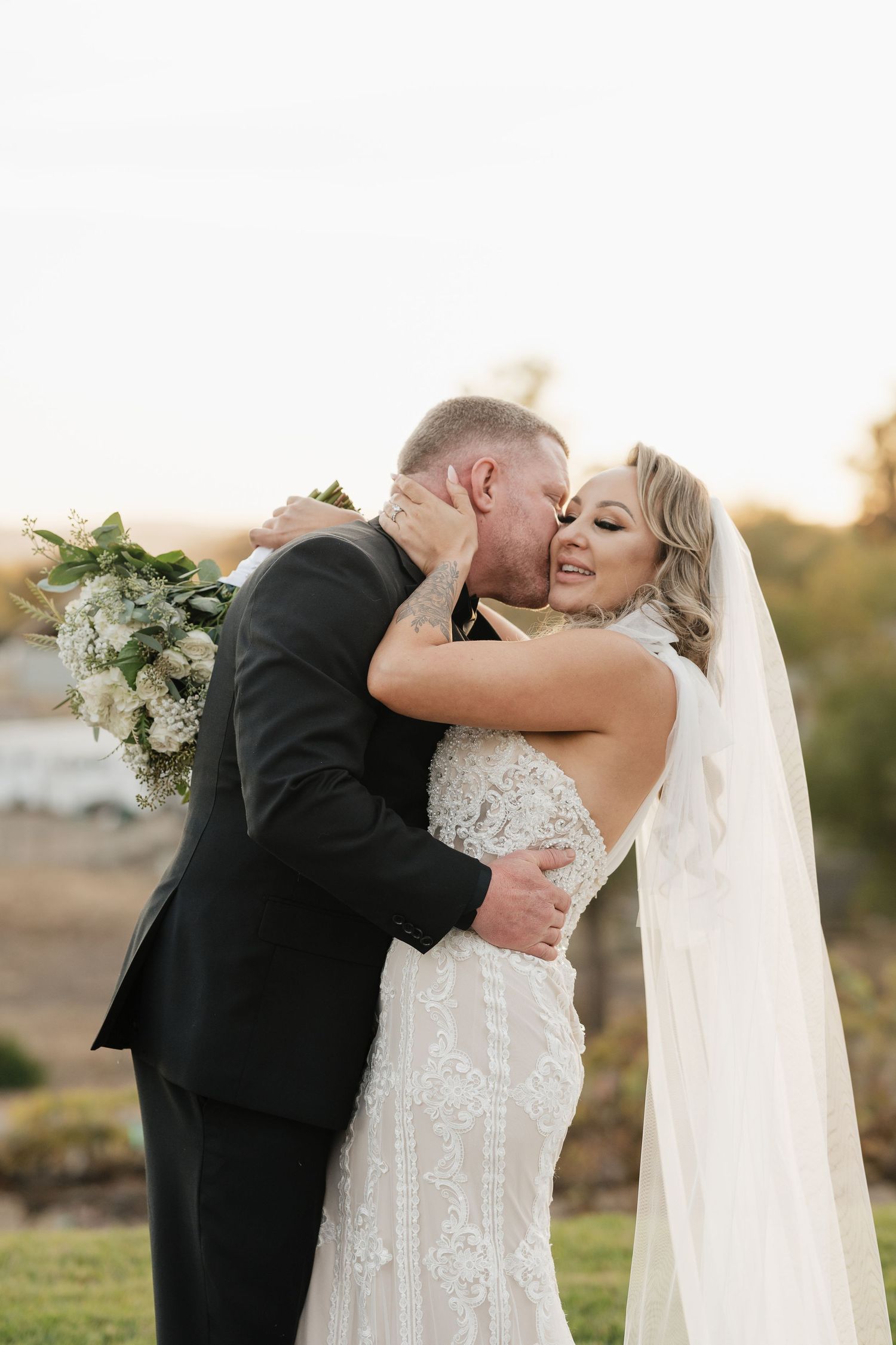 Bride and groom share an intimate embrace during sunset wedding photos.
