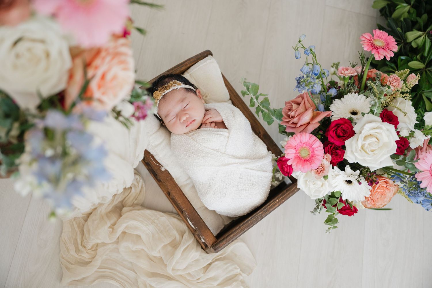 Delicate floral arrangements with pink and white roses alongside vintage wooden decor pieces create a romantic setting.