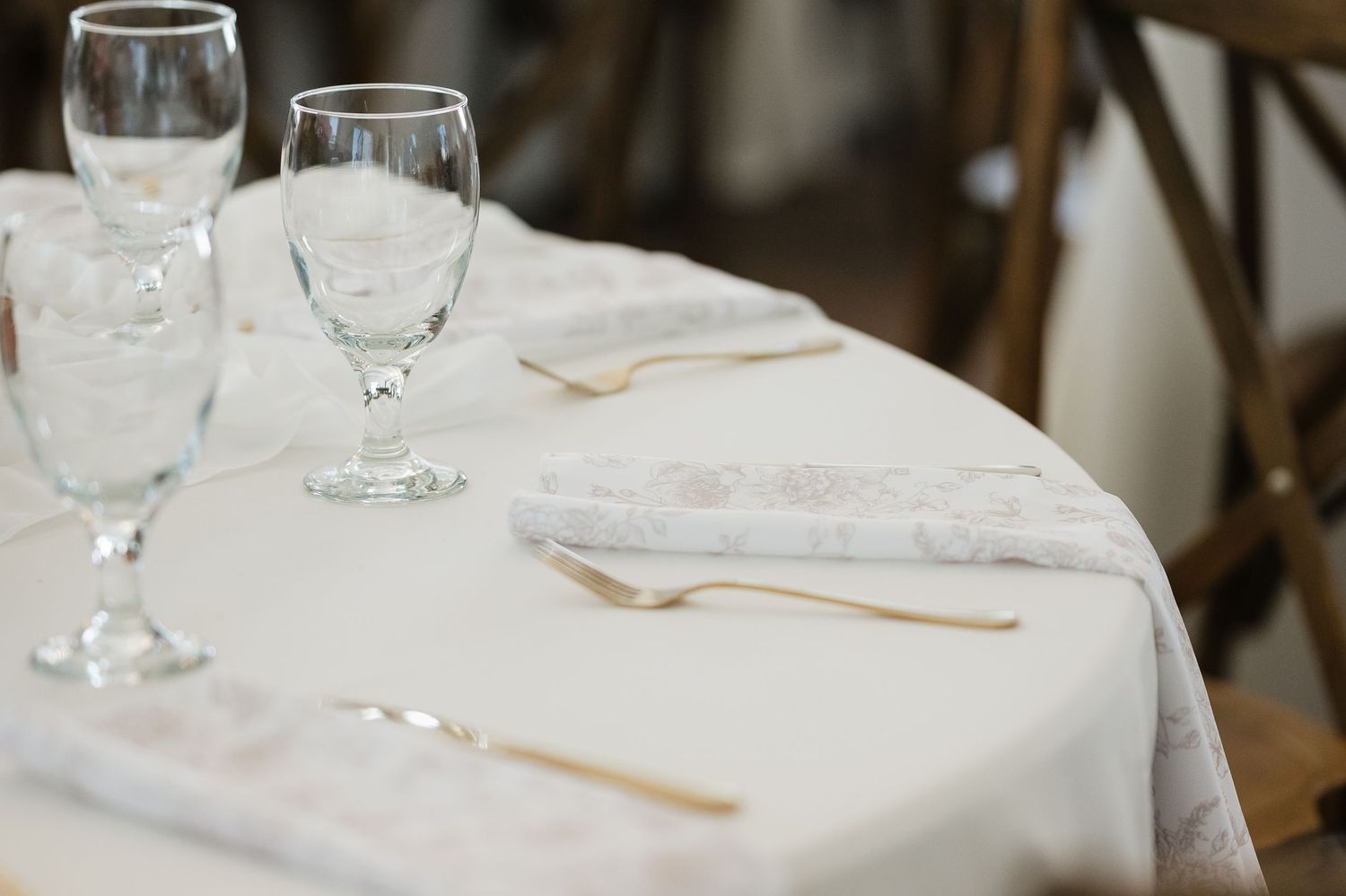 White tablecloths and place settings arranged for an elegant wedding reception.