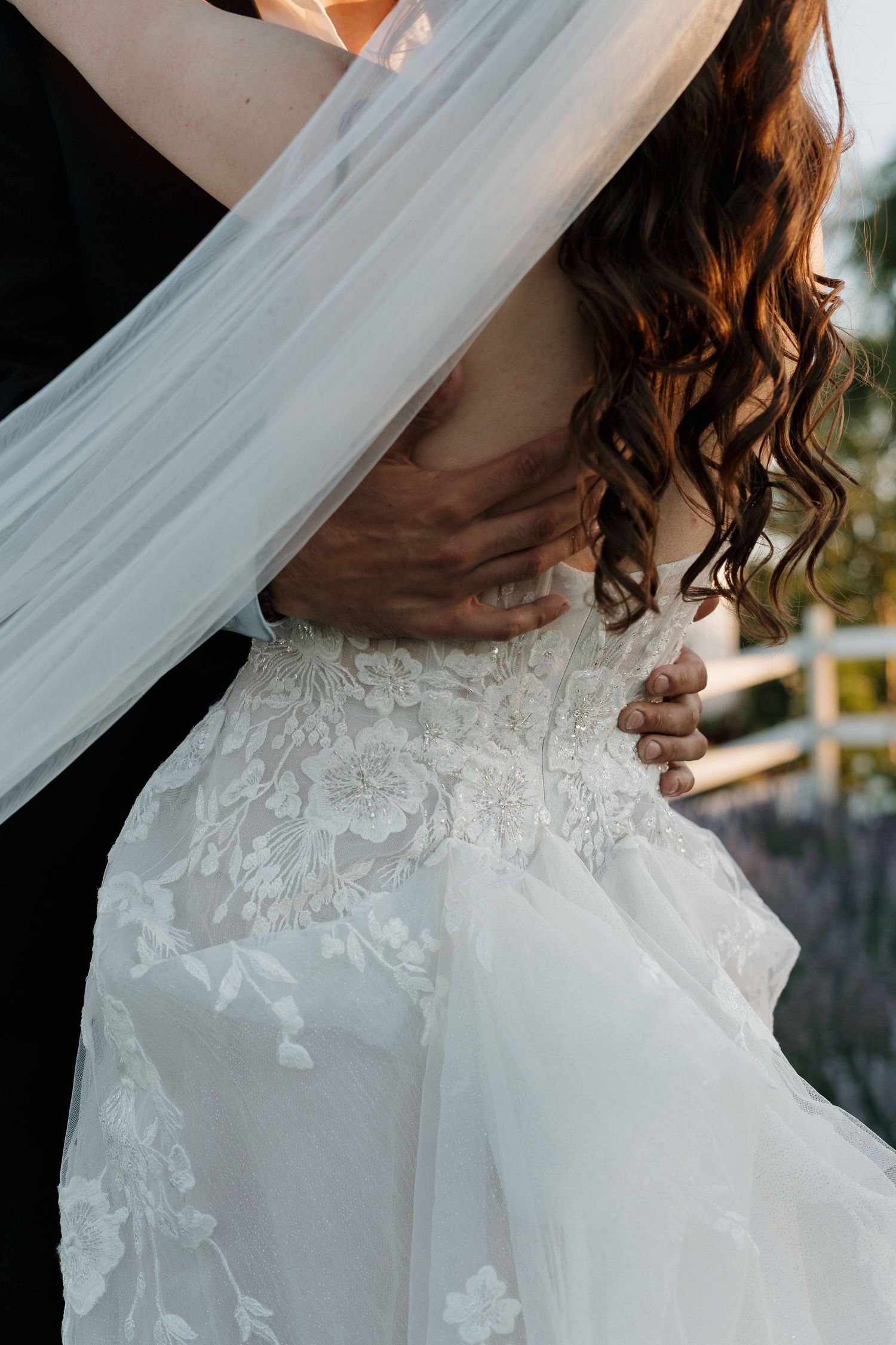 Close-up details of delicate white lace and tulle on a wedding dress.