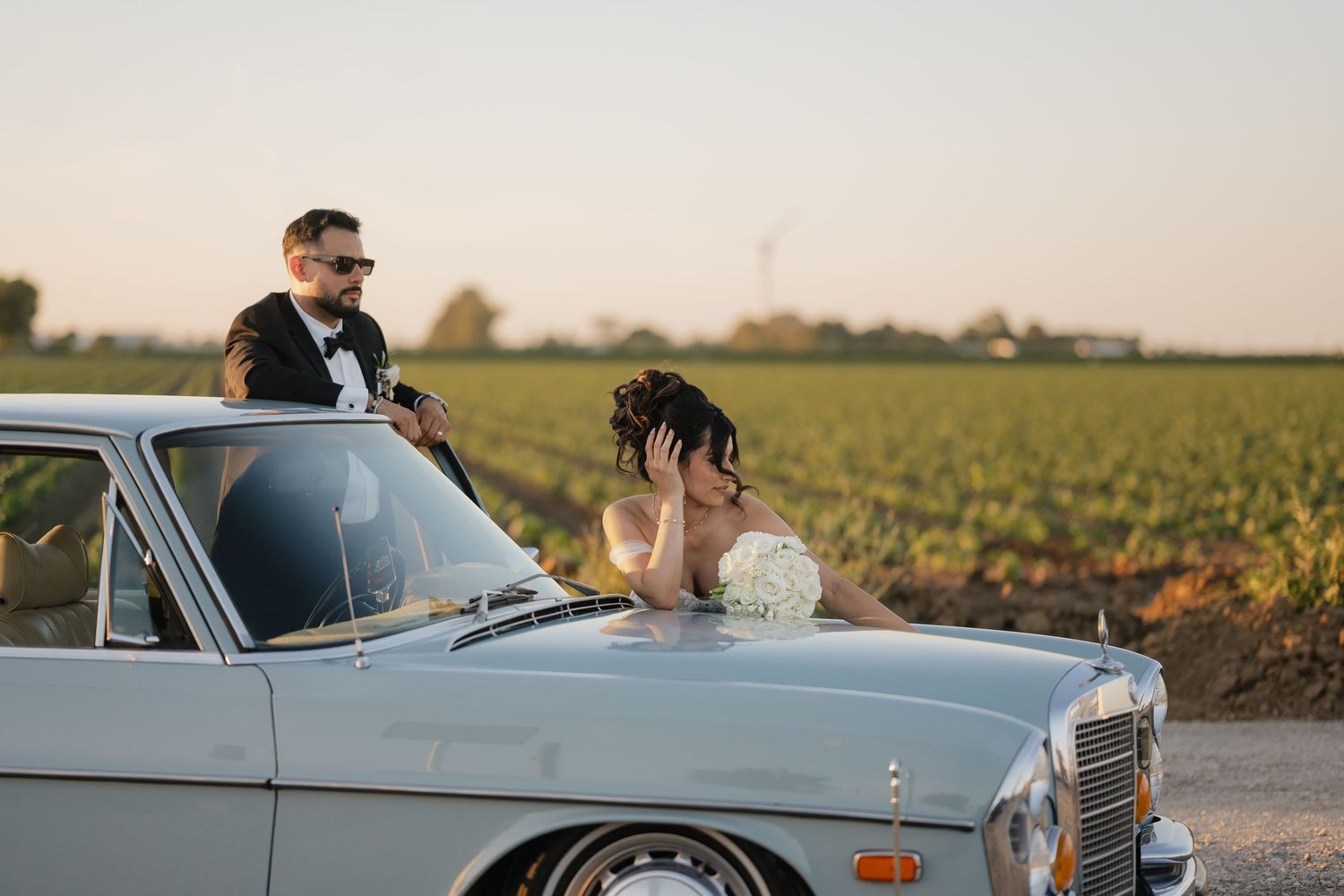 Classic vintage car wedding photoshoot in golden hour sunlight.