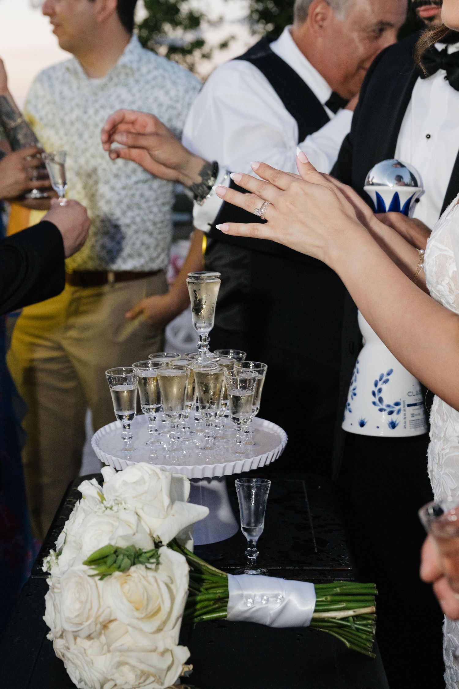 White floral bouquet and champagne glasses being served at an elegant wedding reception.