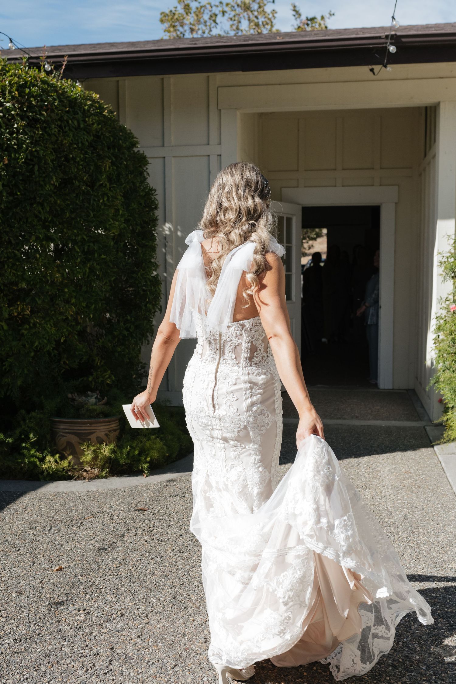 Wedding dress movement captured while walking on gravel path.