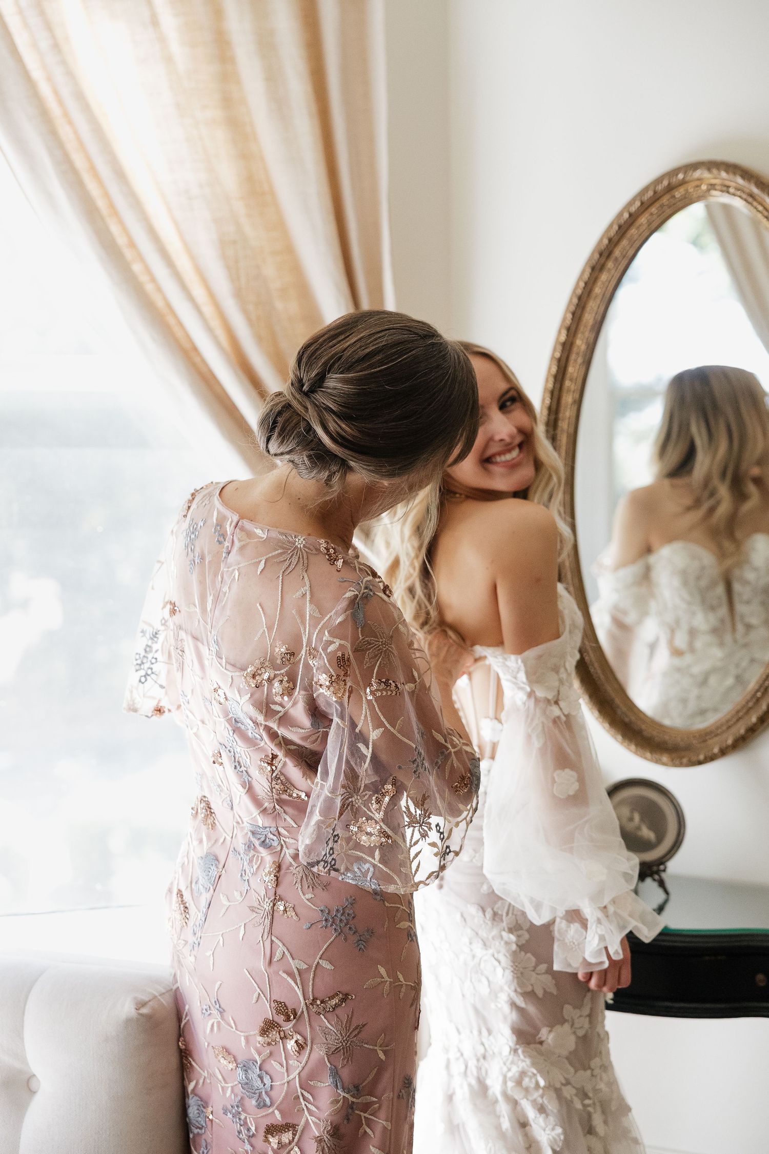 Elegant pink lace robes with delicate floral patterns hang in a bridal suite getting ready room.