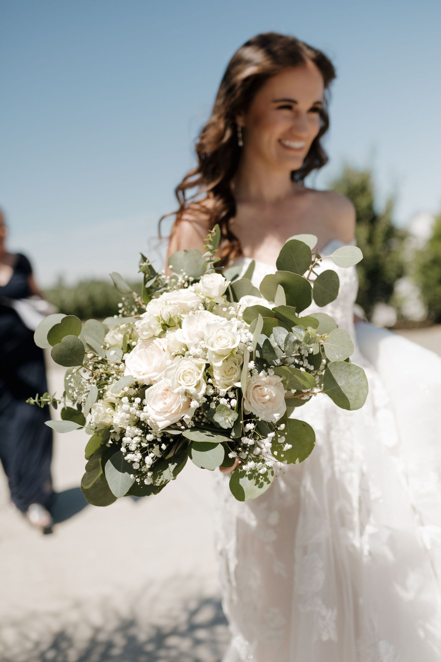 White and green wedding bouquet featuring eucalyptus leaves and delicate flowers.