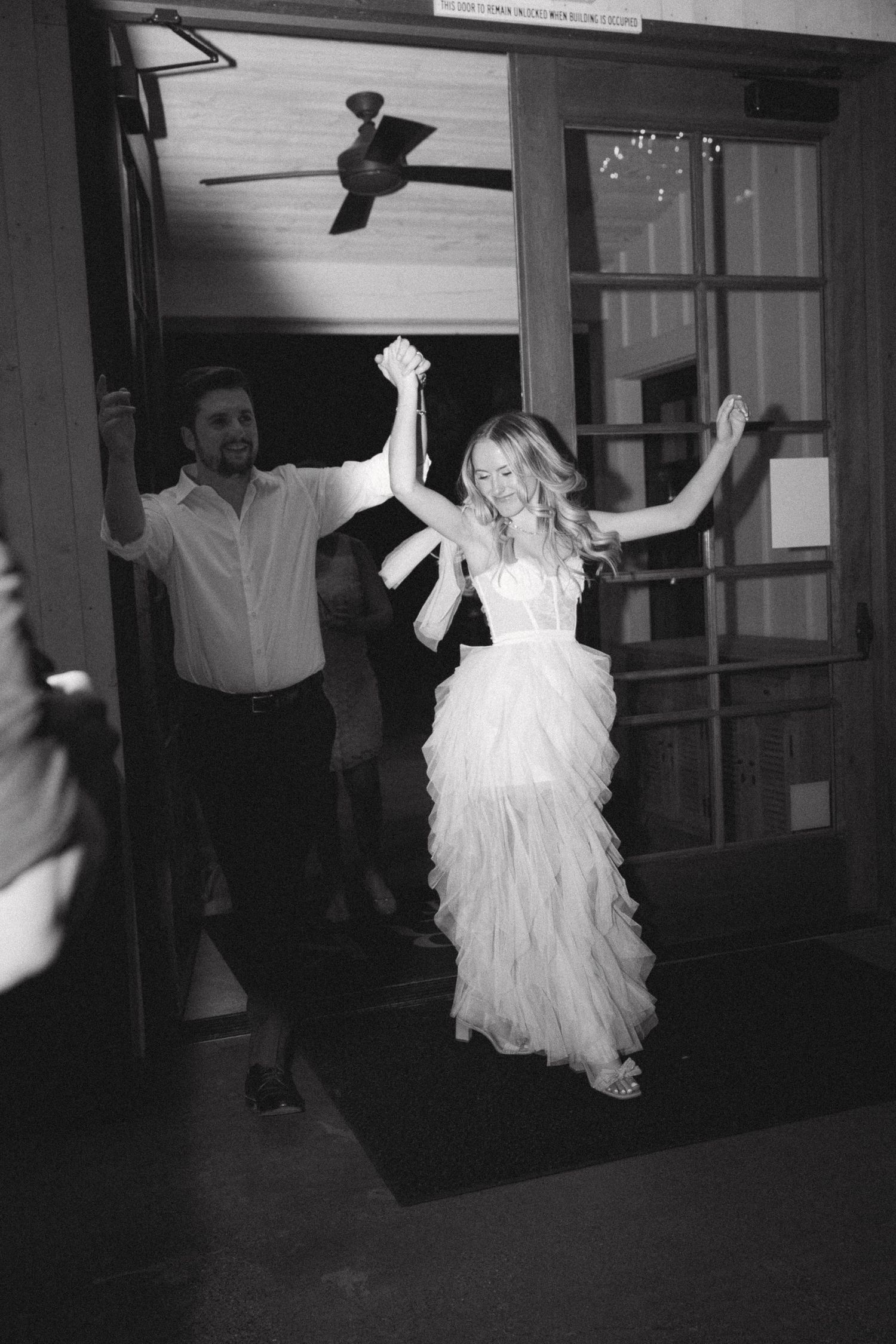 Black and white photos showing dancers in flowing white dresses performing in a dark indoor space.