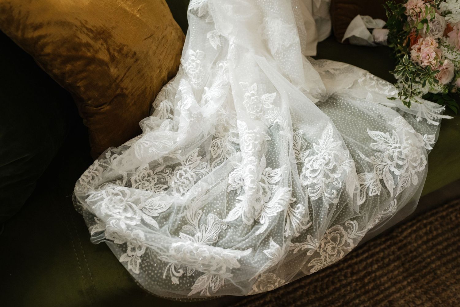Close-up details of intricate lace patterns on a white wedding dress.