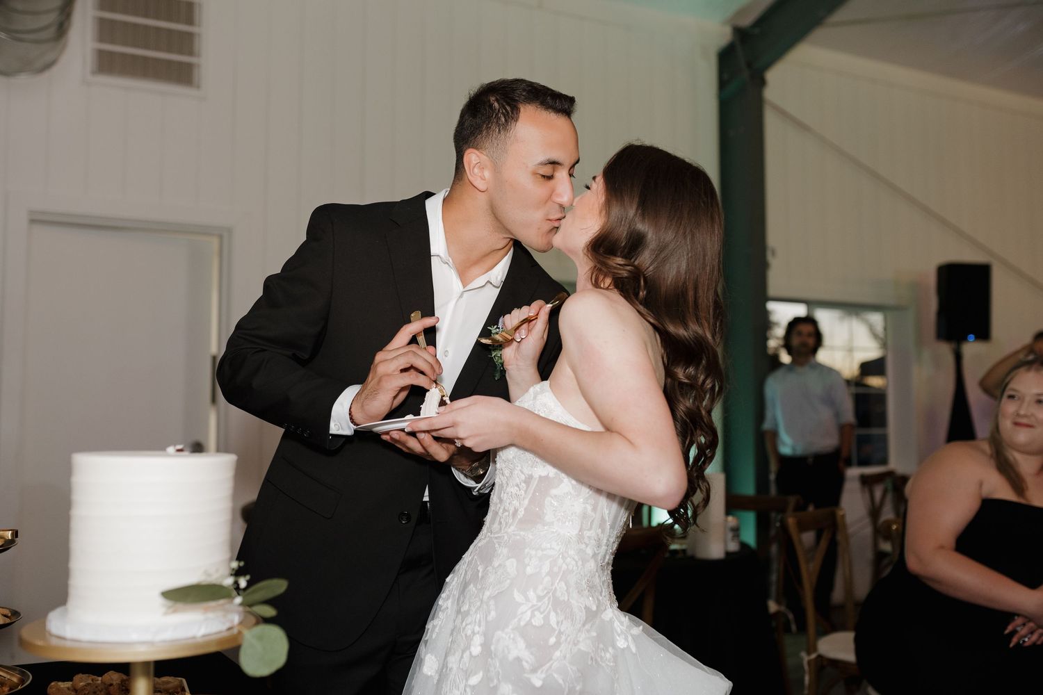 Newlyweds enjoy their first bite of wedding cake at reception.