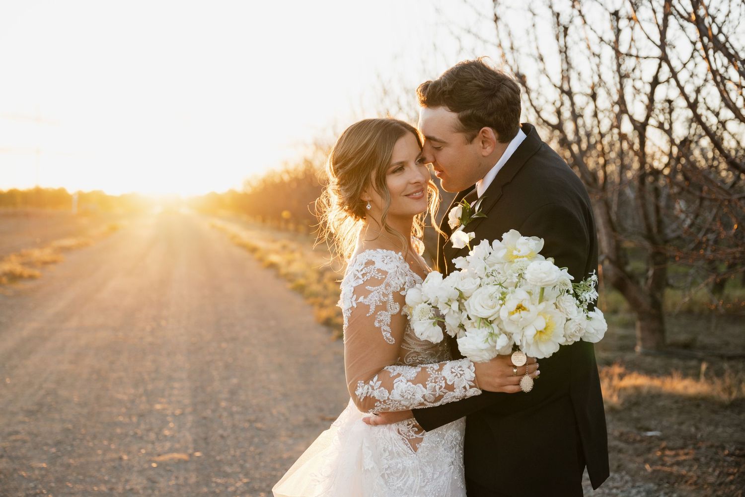 Romantic sunset wedding portraits in rustic outdoor setting.