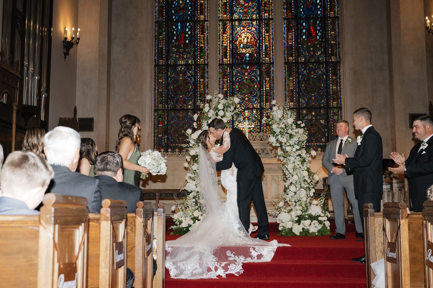 Traditional church wedding ceremony with red carpet aisle and floral decorations.