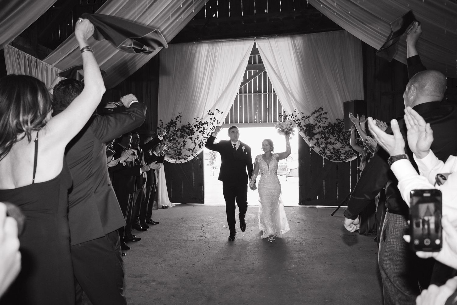 Wedding reception guests celebrate on the dance floor under elegant draping.