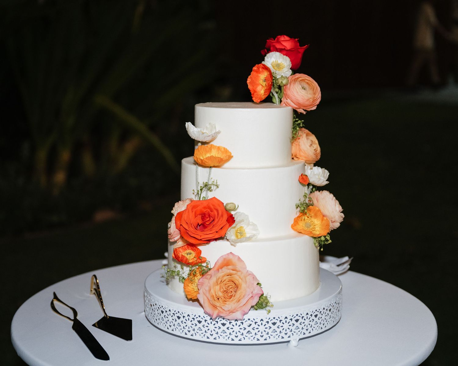 White wedding cake decorated with delicate peach and orange roses.
