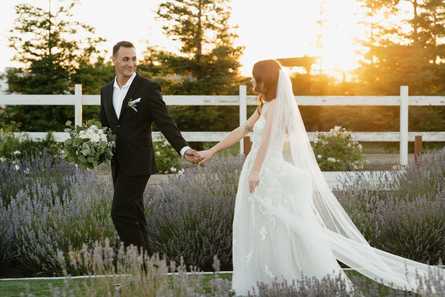 Couple posing in a lavender garden during golden hour wedding photos with dramatic sunset lighting.