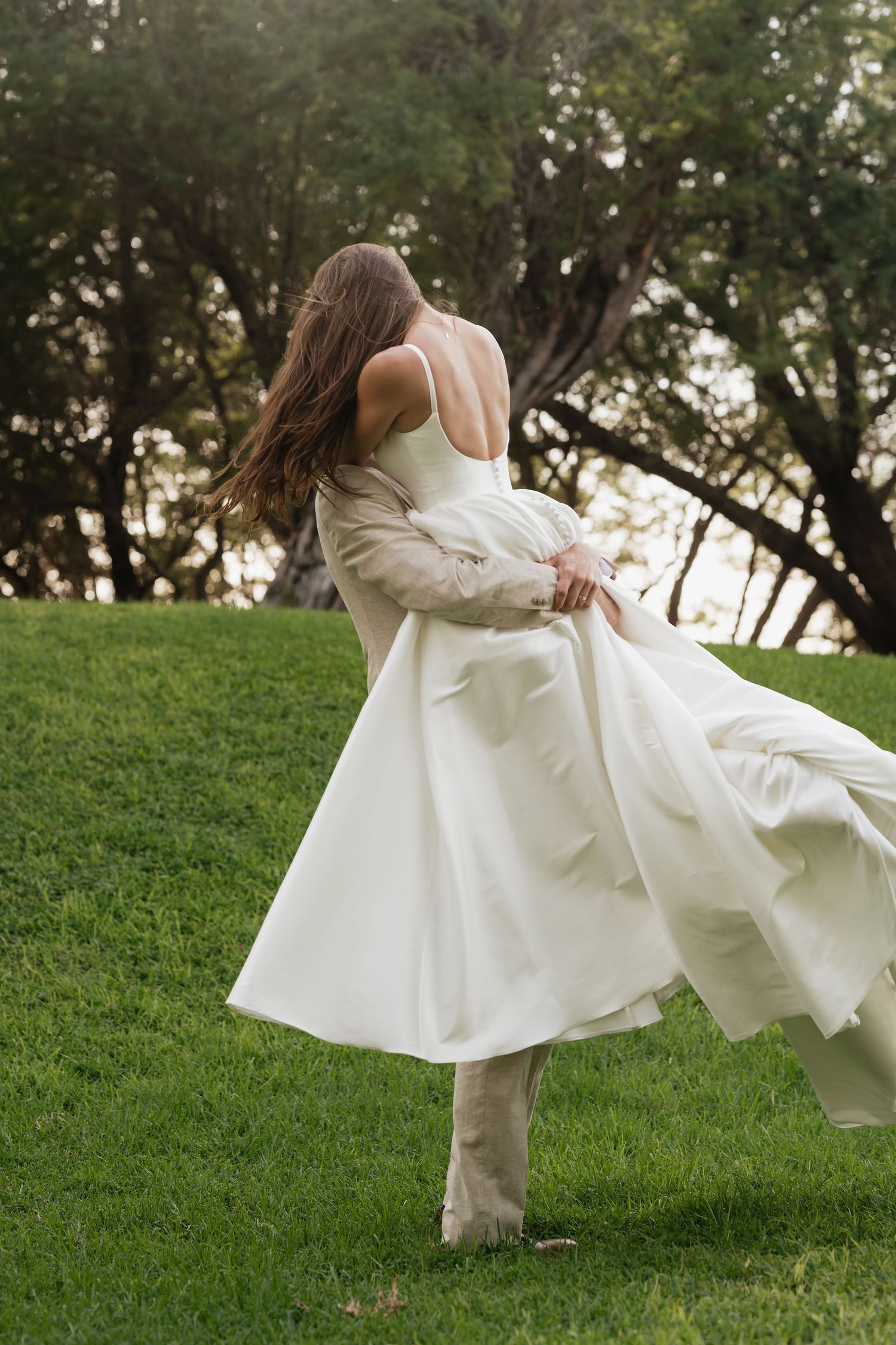 A series of photos showing a flowing white dress twirling on a grassy hillside in an artistic motion sequence.