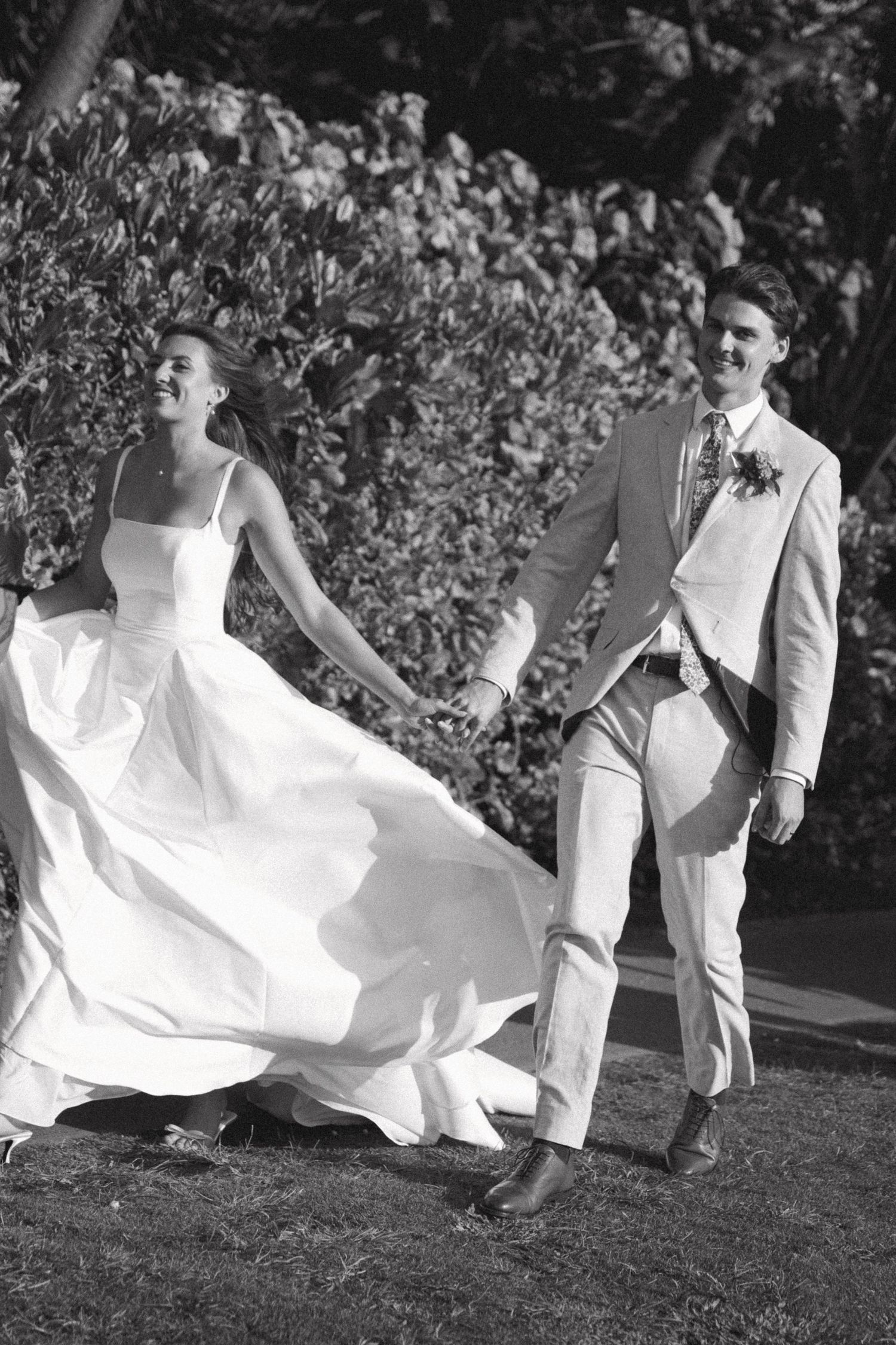 Black and white photo of wedding couple dancing with dress flowing in motion.
