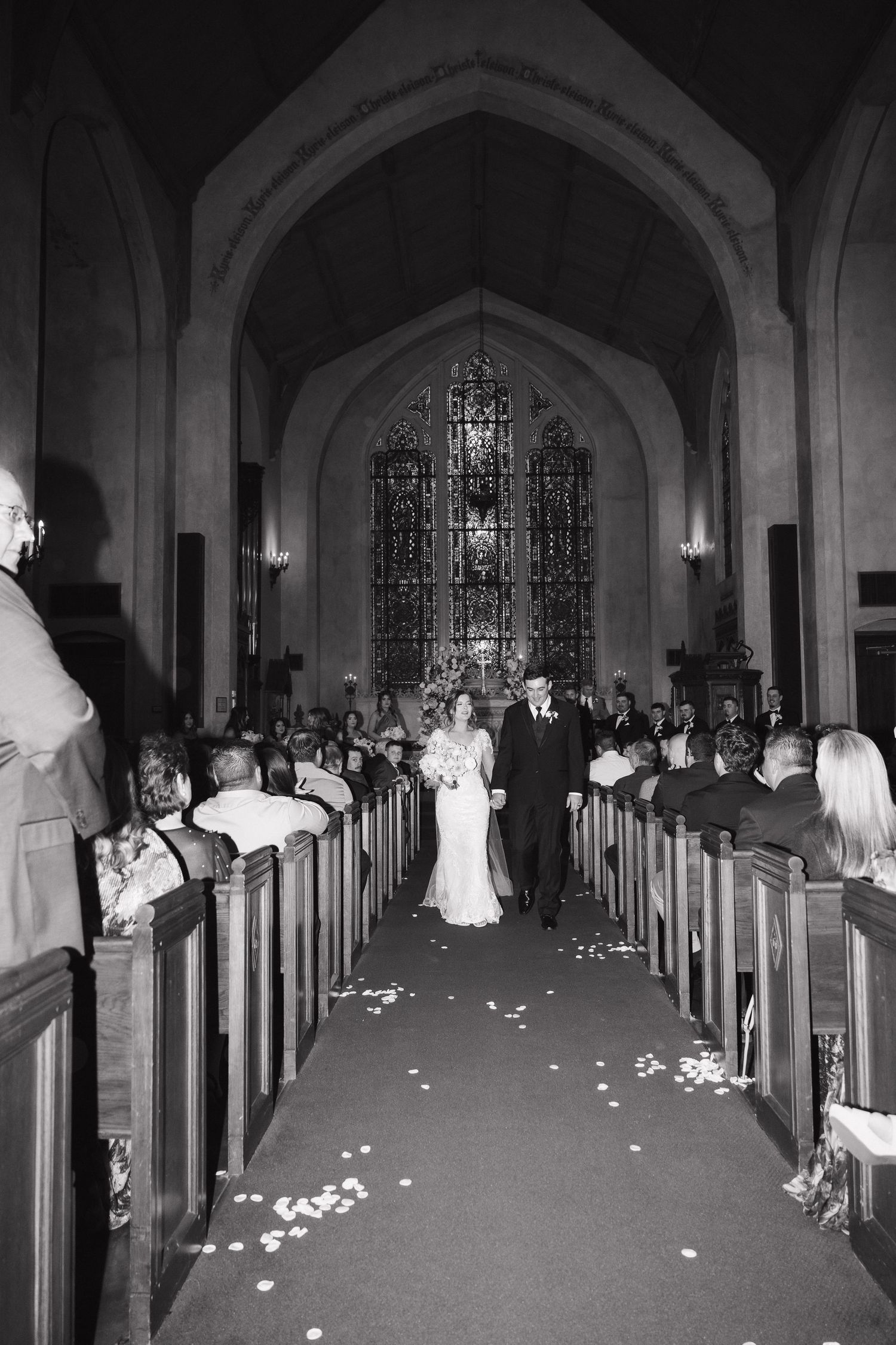 Church interior aisle decorated with petals and florals for a wedding ceremony.