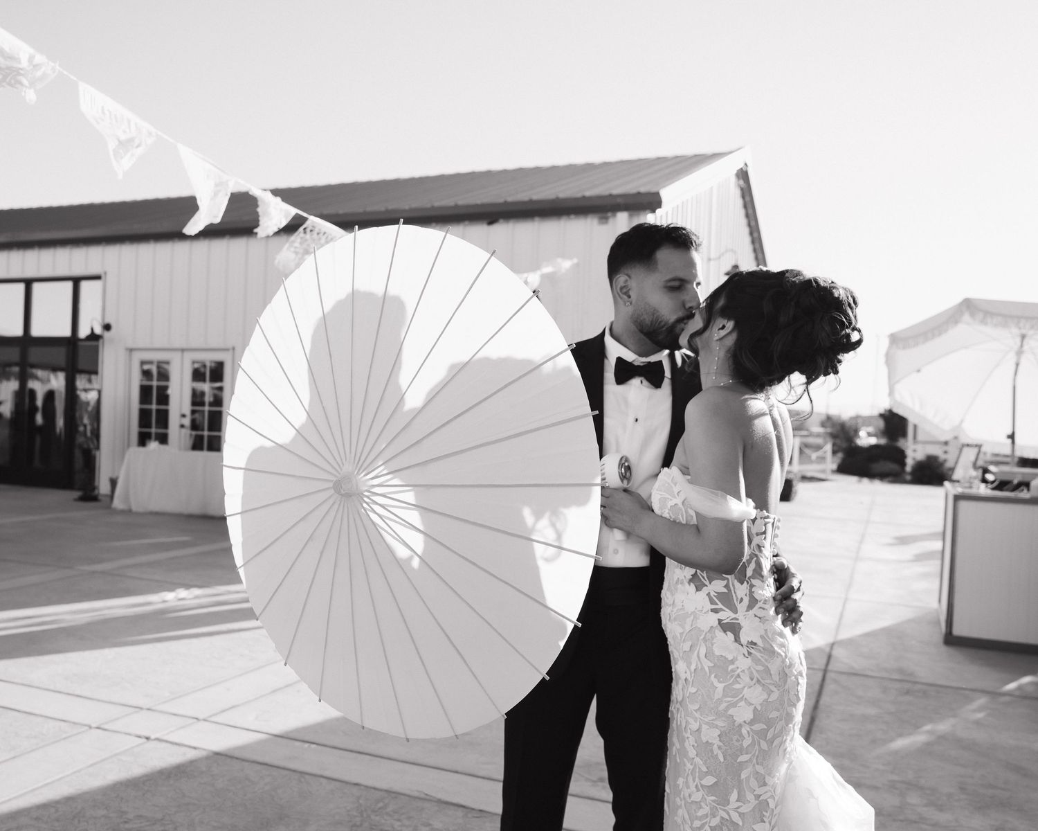 Artistic wedding photos with decorative white parasol in natural lighting.