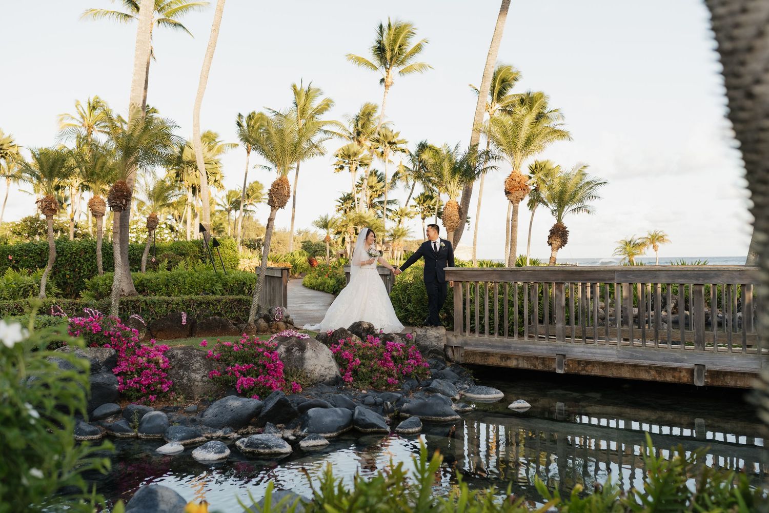 Wedding photos taken on a scenic tropical resort pathway with ocean views.