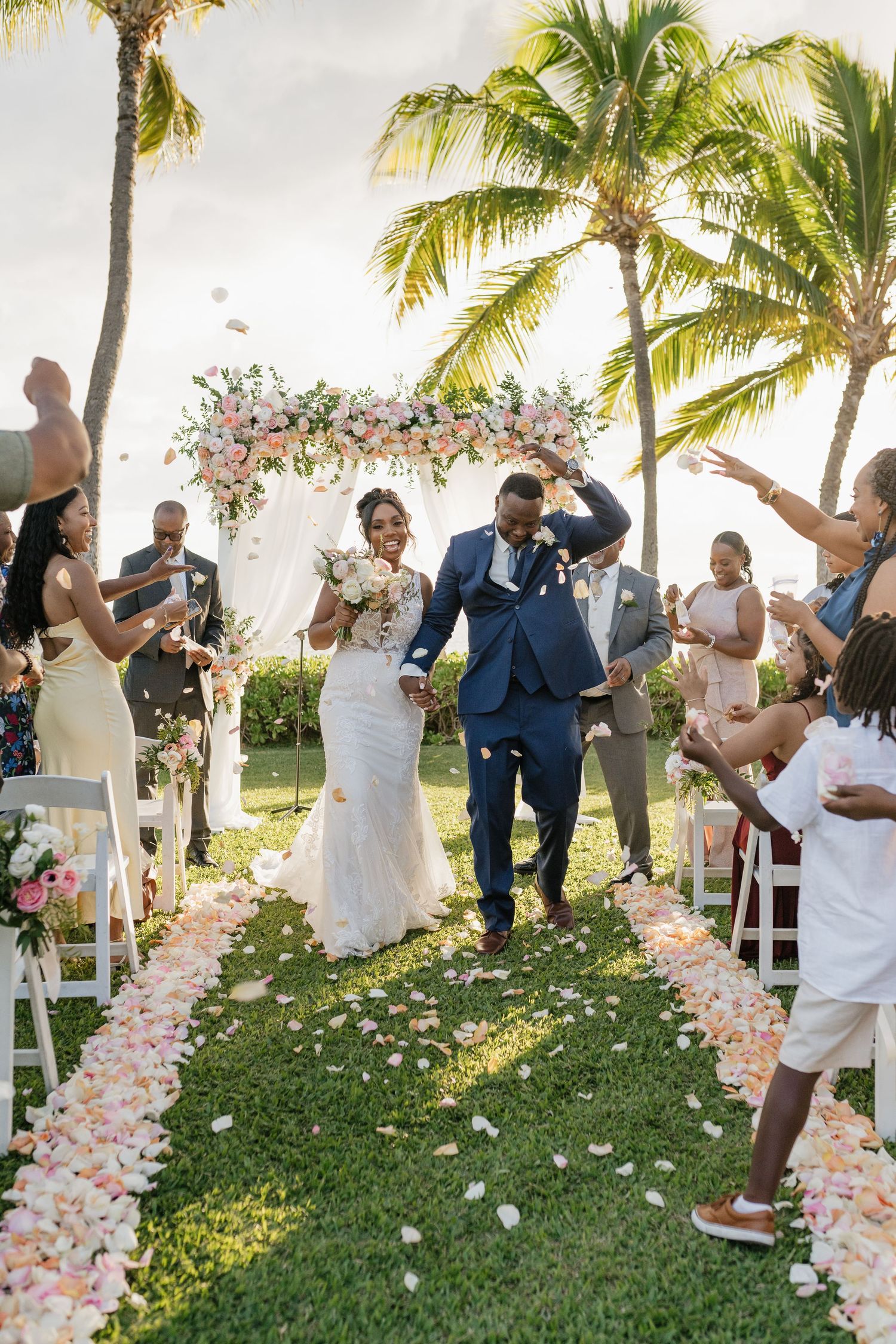 Joyful celebration moment at outdoor wedding with flower petals flying through the air.