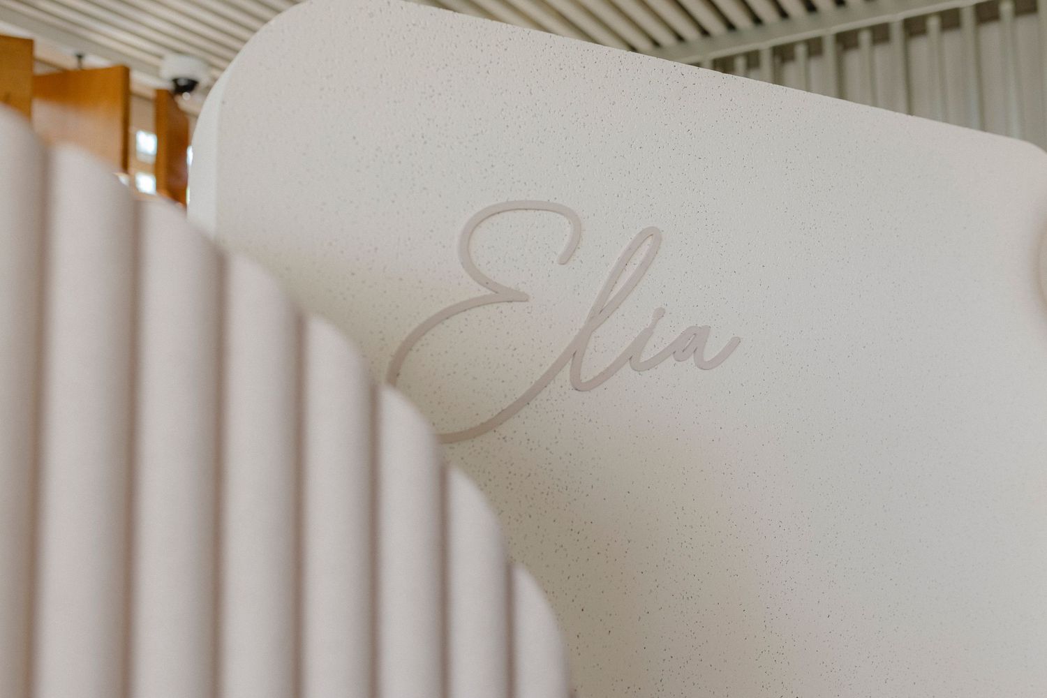 Elegant white curved wall panel with the name Elia written in soft pink cursive script.
